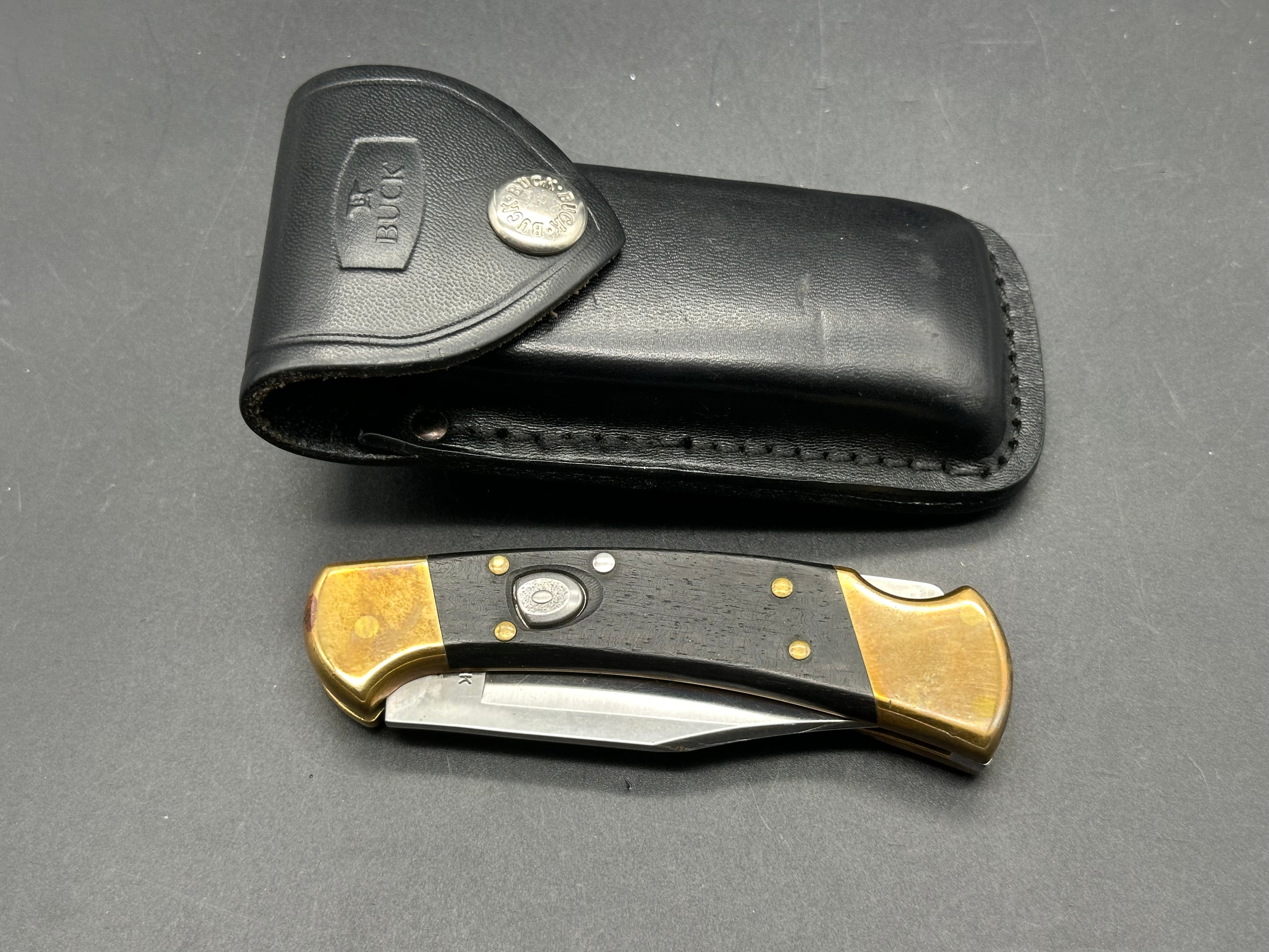 Buck 110 auto used with leather belt carrying pouch