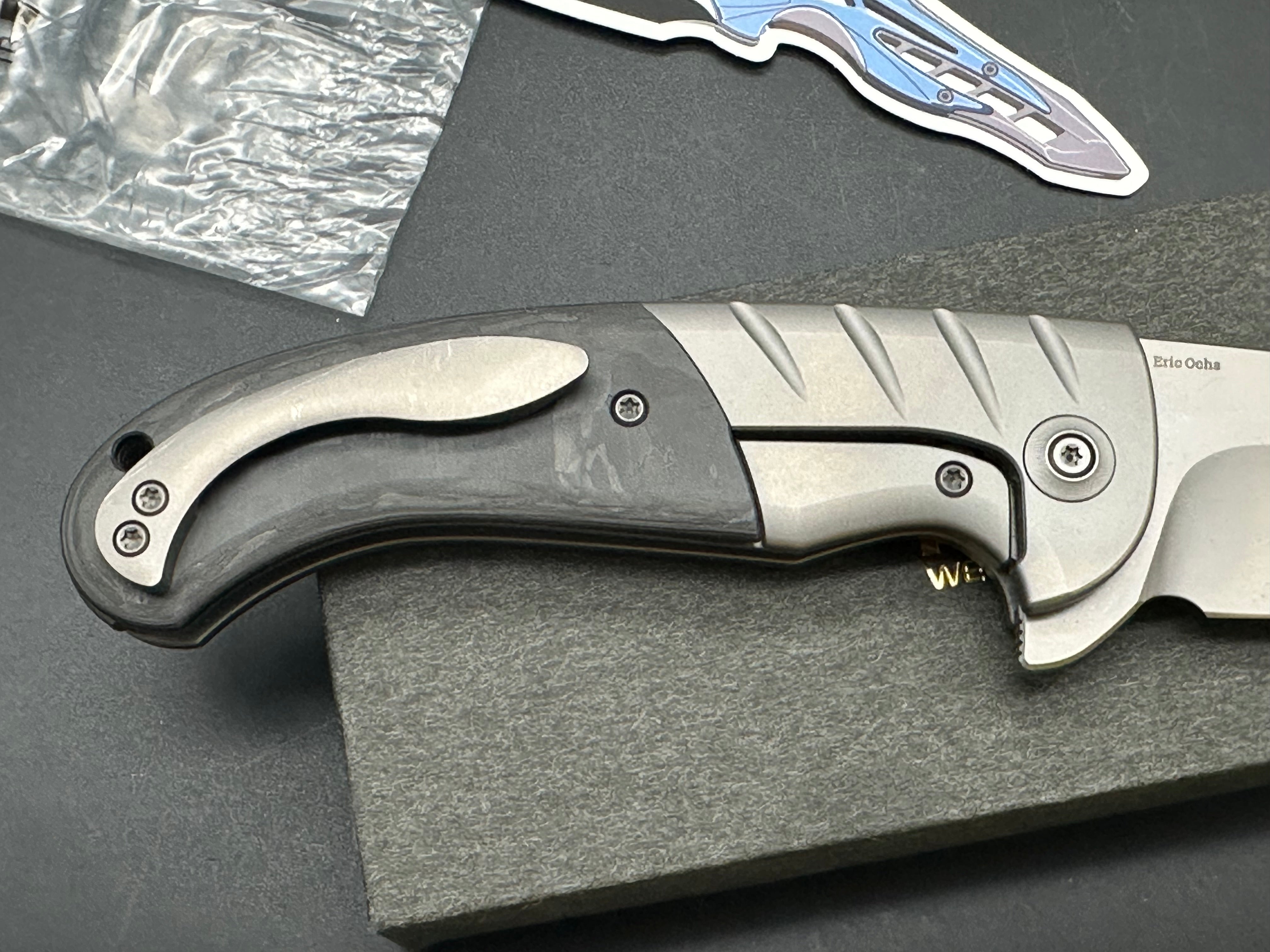 WE CURVACEOUS FOLDING KNIFE TITANIUM/MARBLE CARBON FIBER HANDLE 20CV PLAIN EDGE