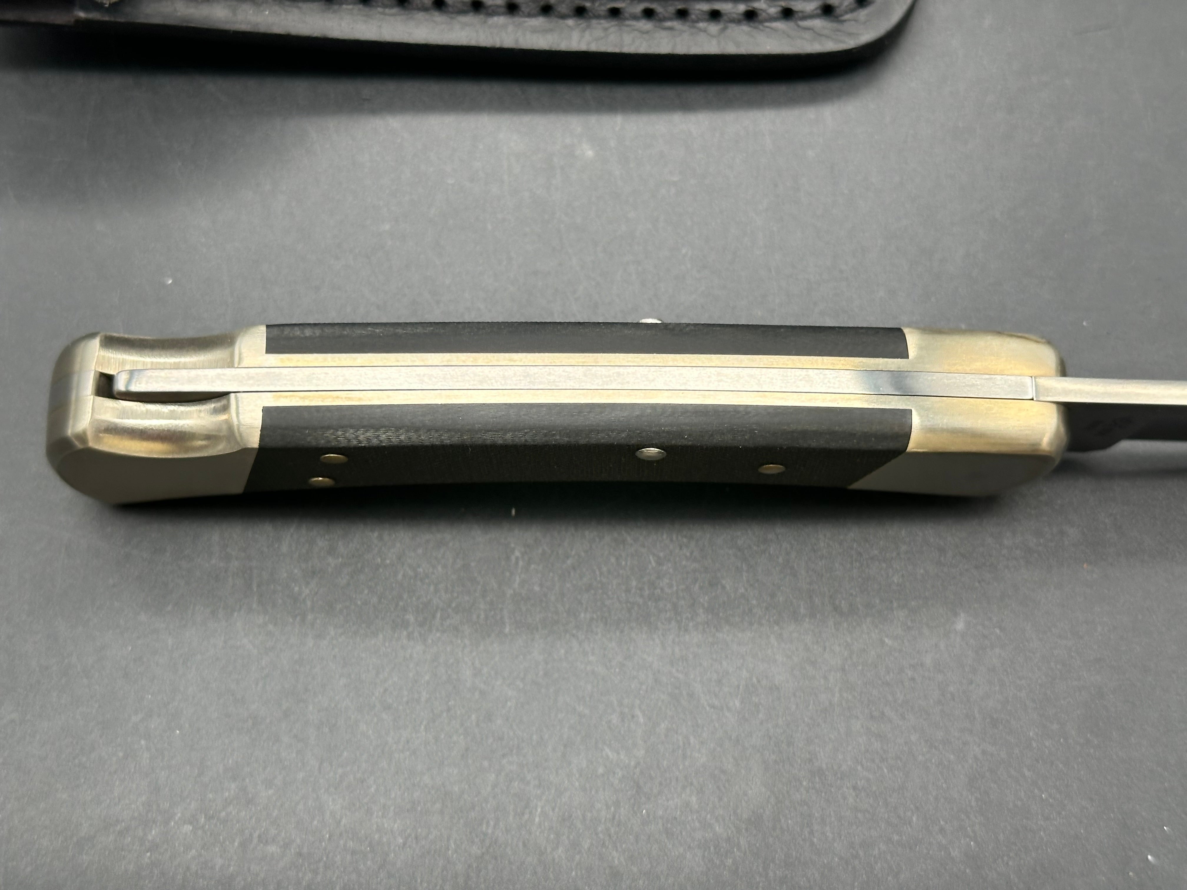 Buck 110, black G-10 scales, nickel bolsters, with scabbard