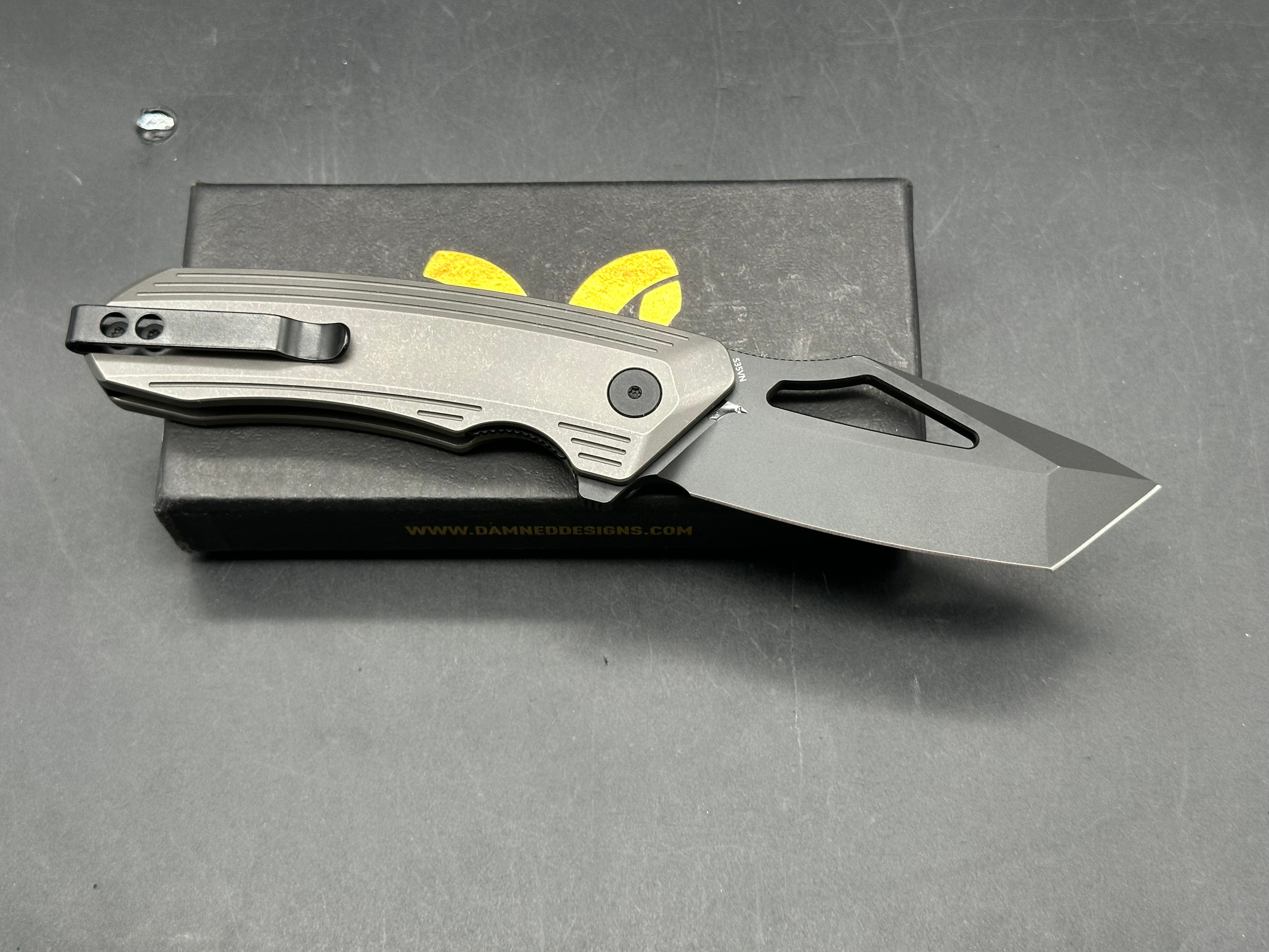 Damned Designs Banshee: 3.1 inch hollow grind, stonewashed, blackwashed CPM-S35VN blade. Ceramic ball bearings