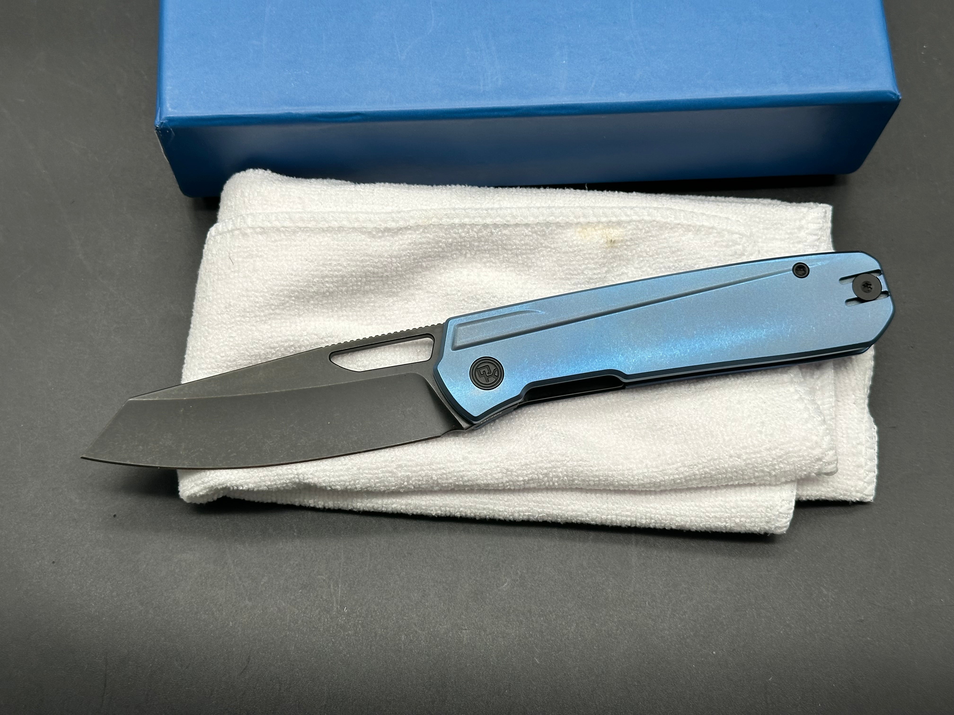 Divo Mash: 3.5 inch blackwashed 154CM blade. Blue anodized titanium frame. No clip