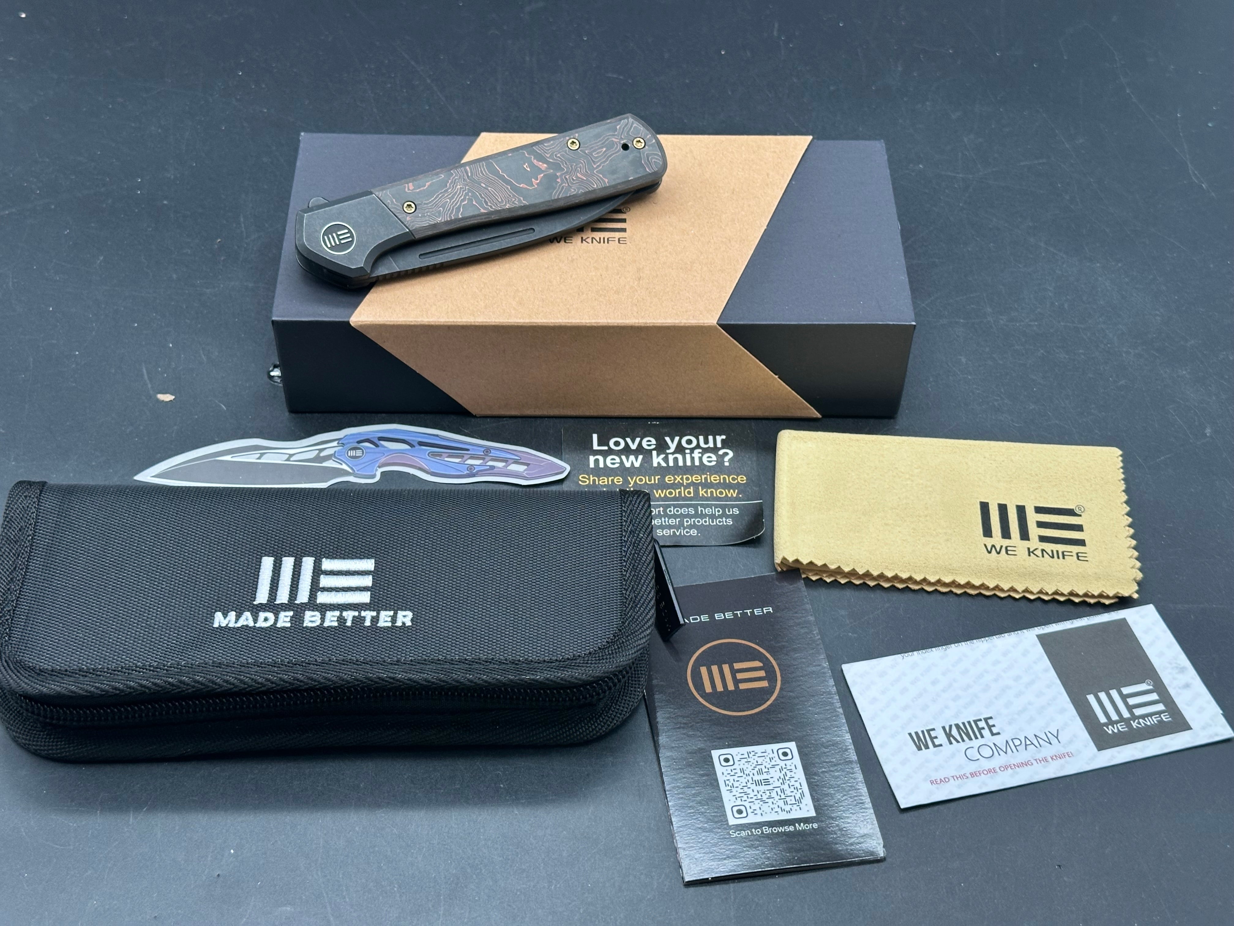 WE SOOTHSAYER FOLDING KNIFE BLACK TITANIUM/COPPER FOIL CARBON FIBER INLAY HANDLE 20CV DROP POINT PLAIN EDGE