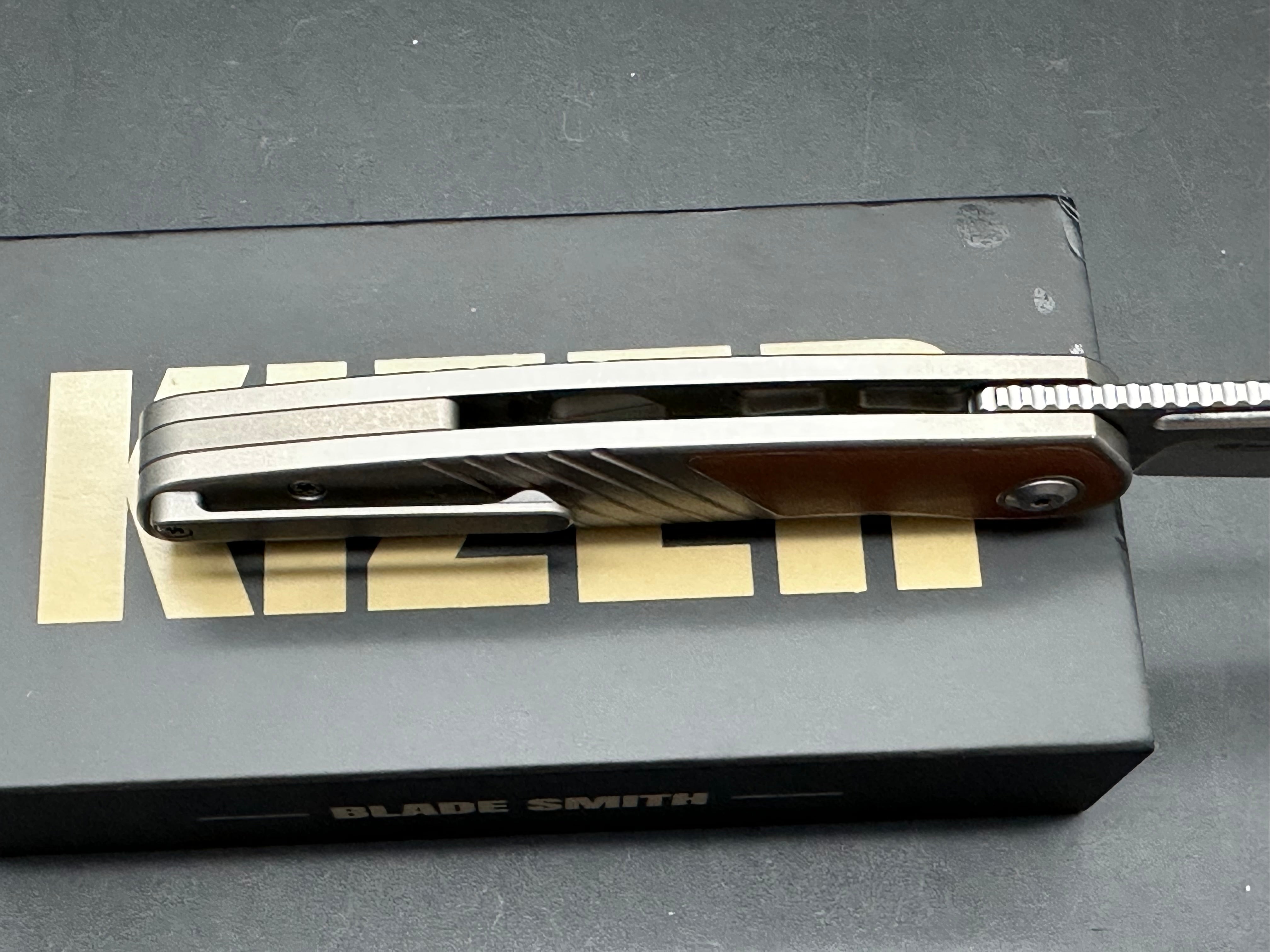 KIZER RAZE SILVER/BROWN TITANIUM/LEATHER HANDLE S45VN CLIP POINT PLAIN EDGE