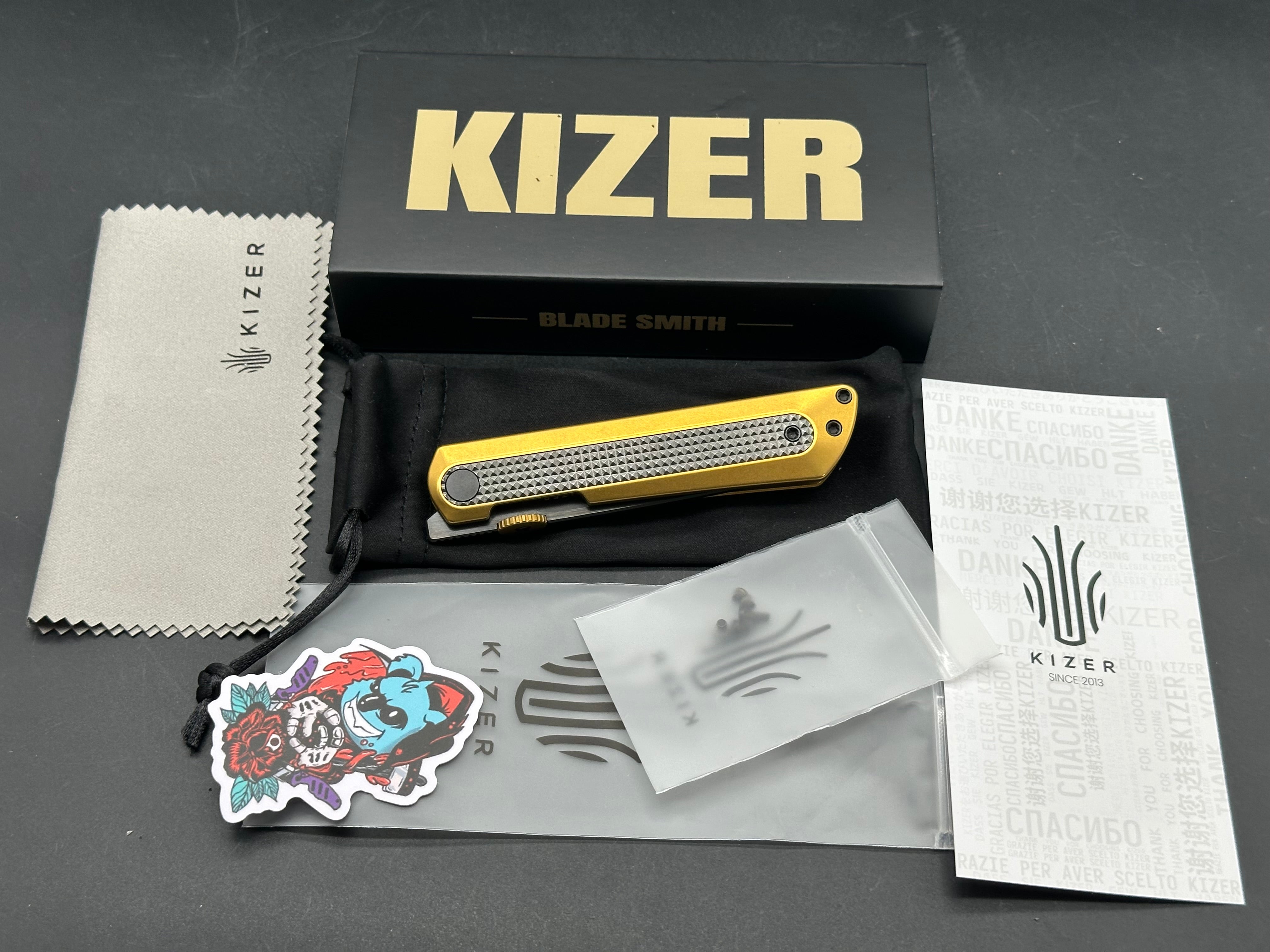 KIZER QUOLL GOLD/BLACK TITANIUM/ZIRCONIUM HANDLE S45VN DROP POINT PLAIN BLACK BLADE