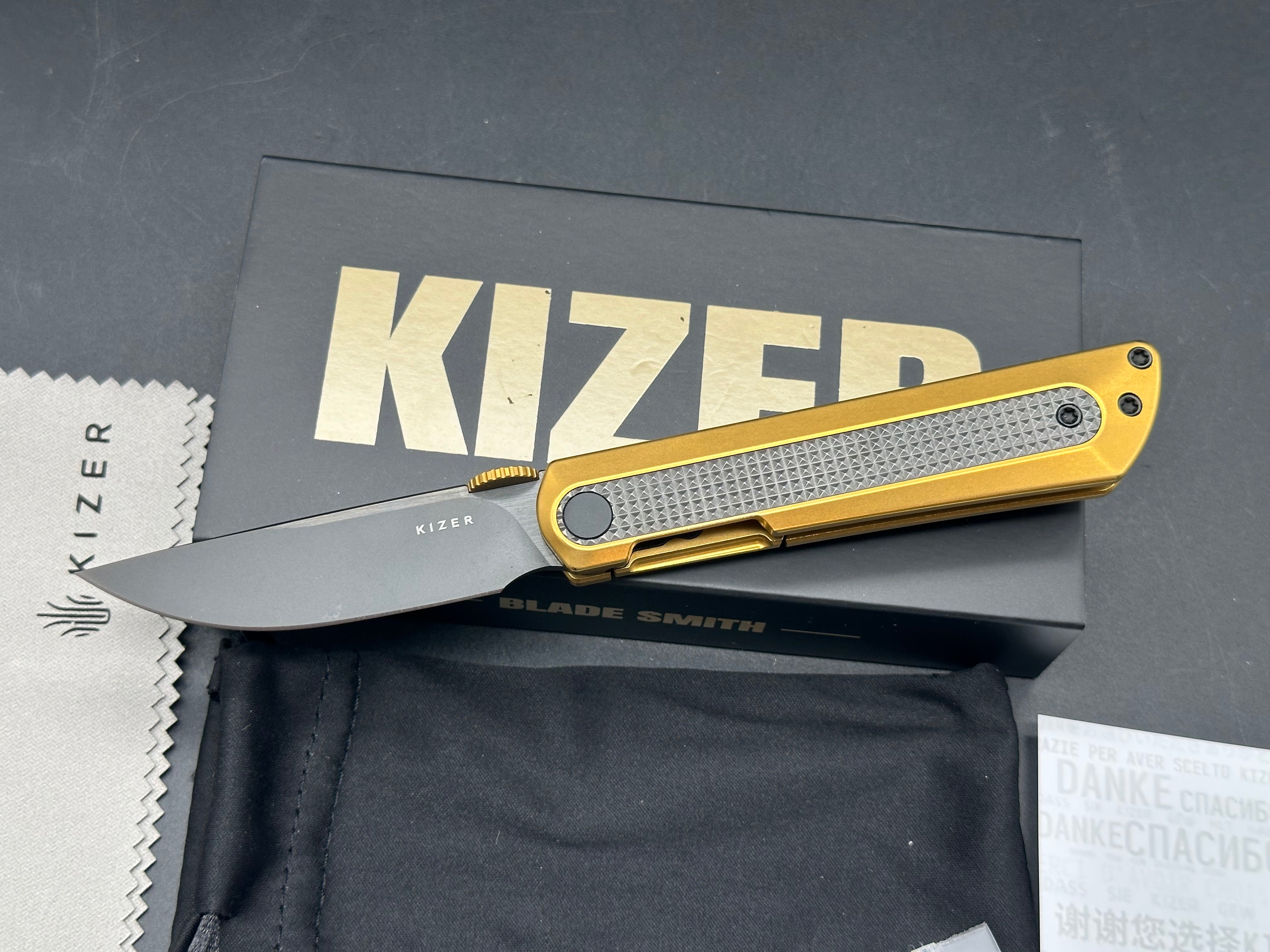 KIZER QUOLL GOLD/BLACK TITANIUM/ZIRCONIUM HANDLE S45VN DROP POINT PLAIN BLACK BLADE