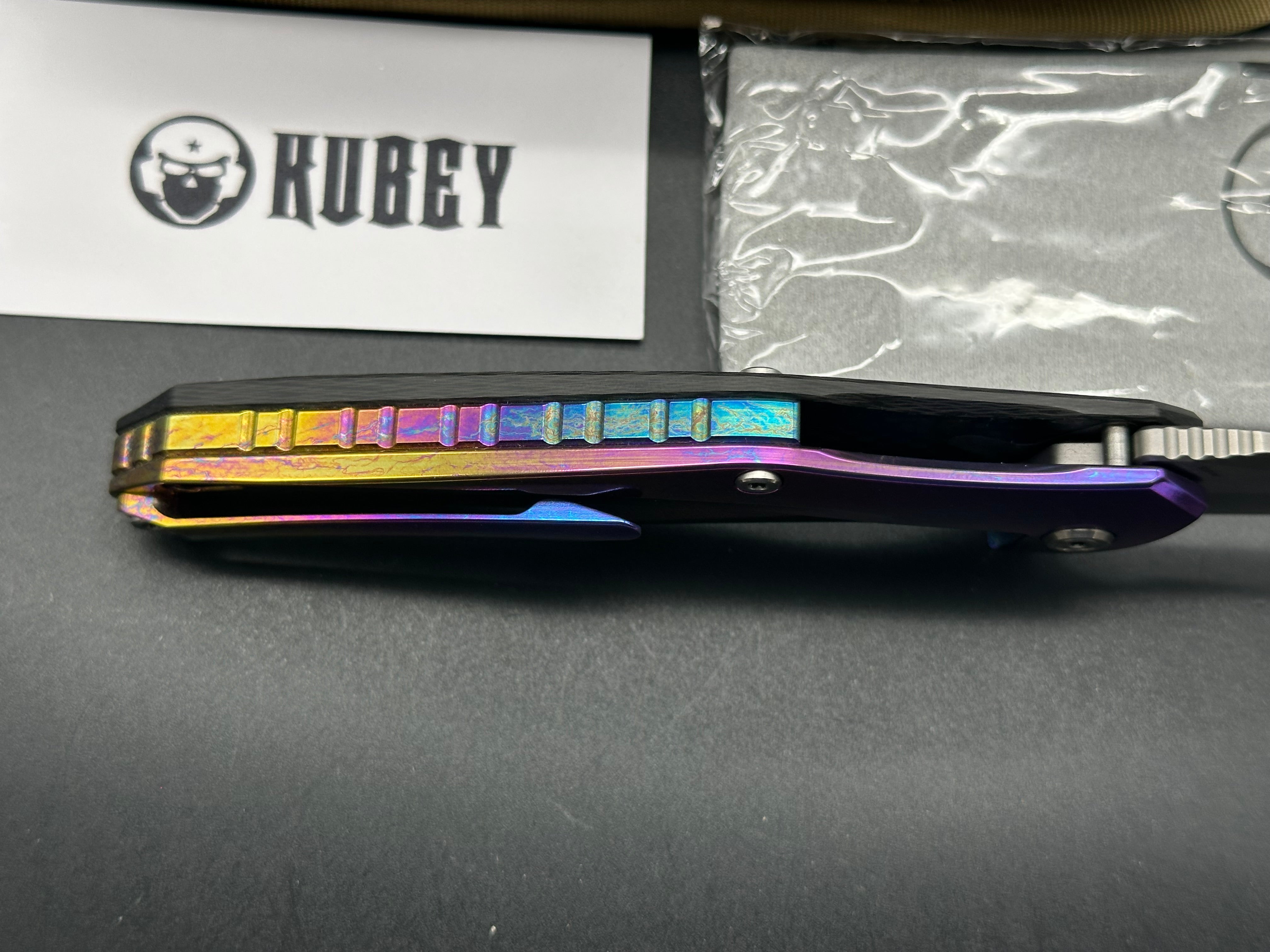 Kubey Caiman colored titanium frame with Carbon Fiber scale