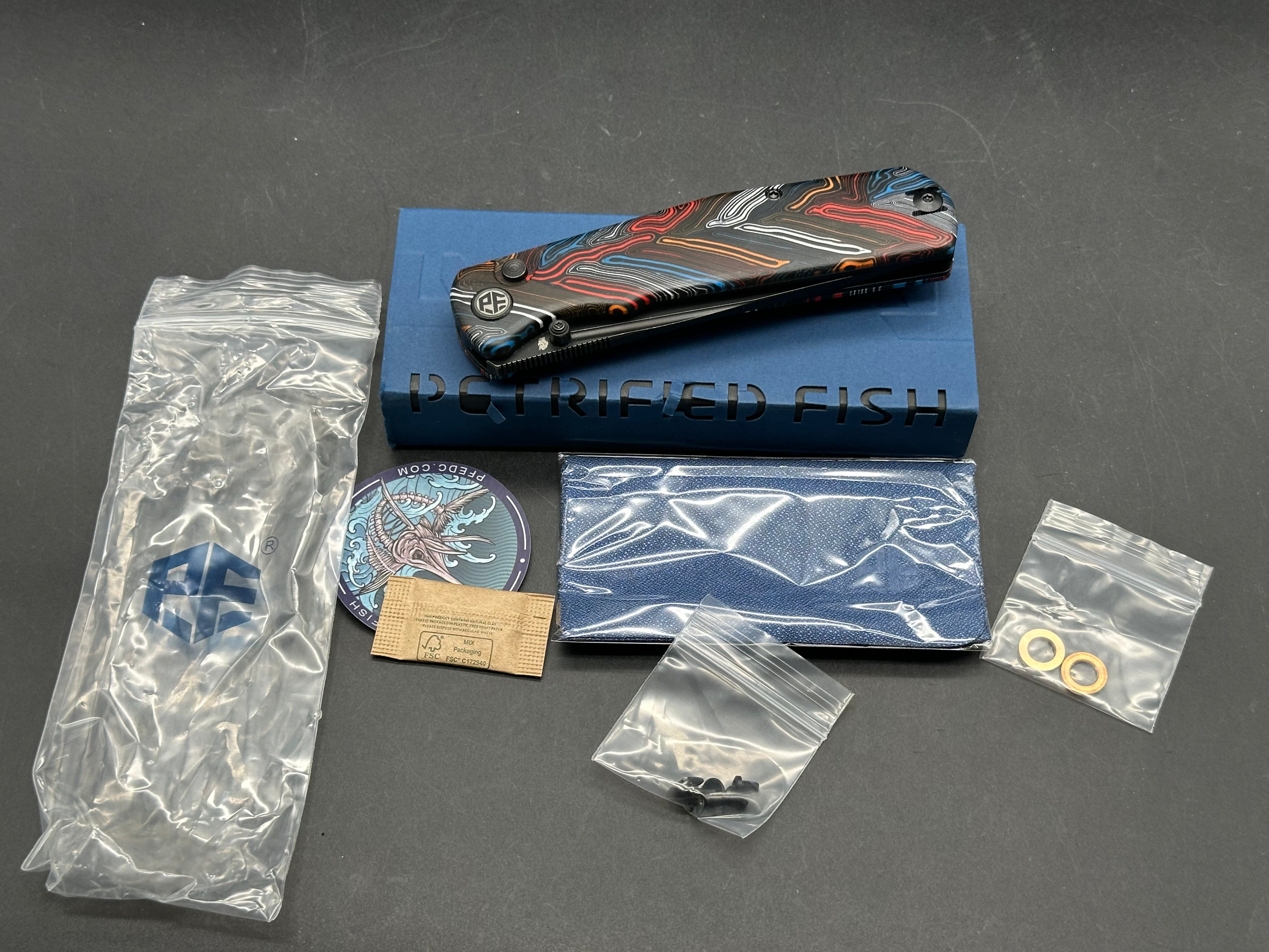 PETRIFIED FISH LIS FOLDING KNIFE BUTTON MULTI COLOR HANDLE 10CR15COMOV BLACK BLADE