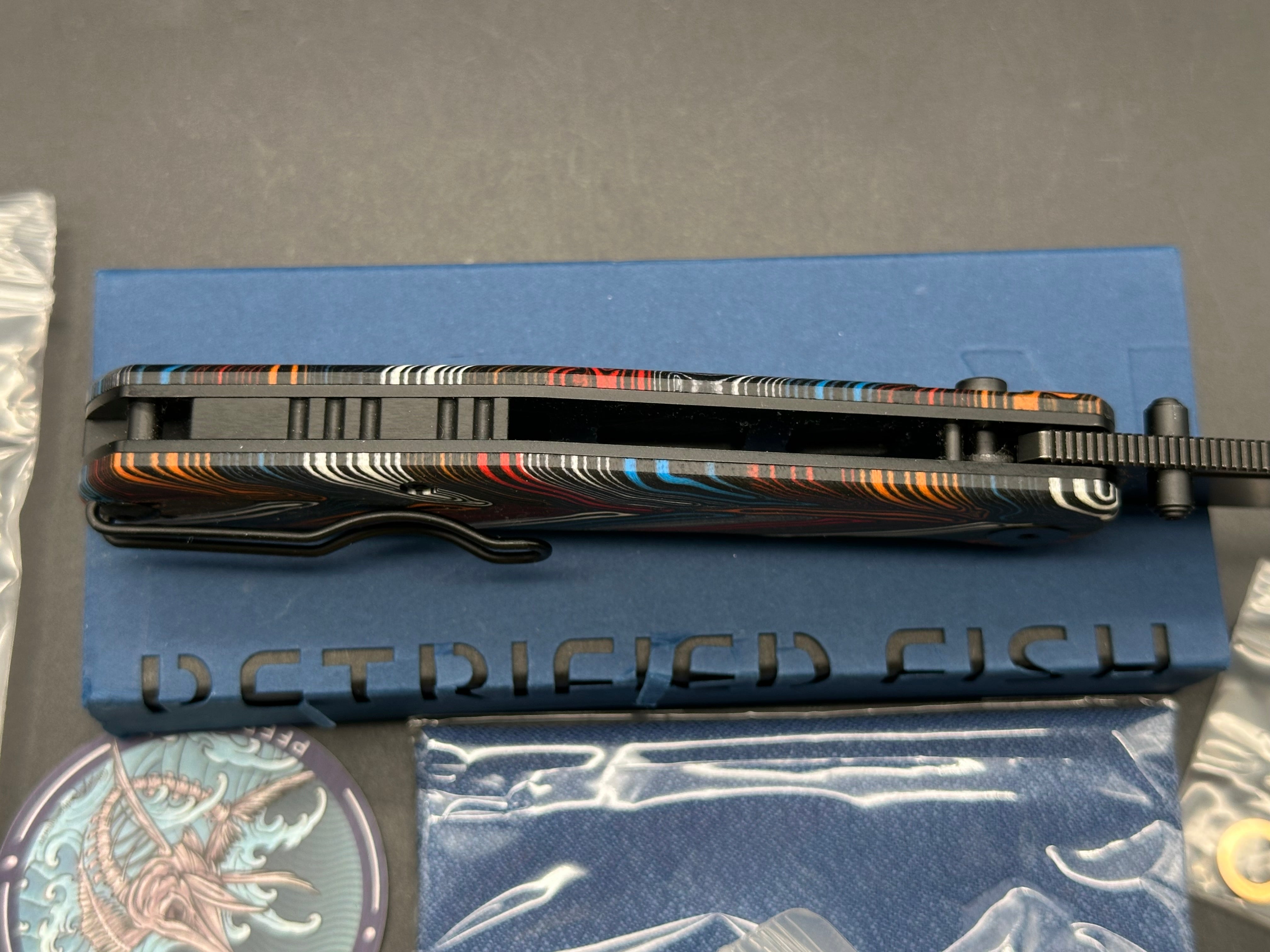 PETRIFIED FISH LIS FOLDING KNIFE BUTTON MULTI COLOR HANDLE 10CR15COMOV BLACK BLADE