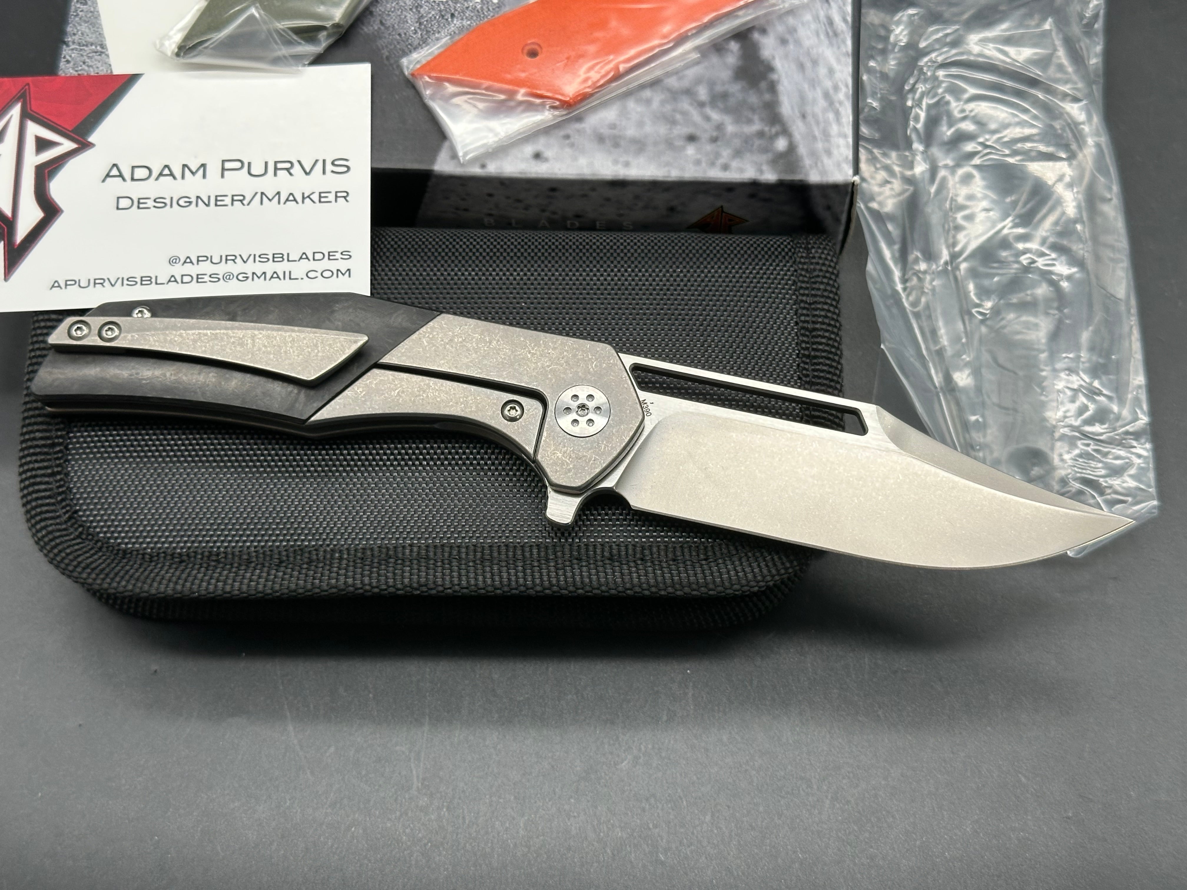 A. Purvis Blades Primordial MK2, Stonewashed M390 Blade Titanium Handles with Marbled Carbon Fiber Overlays