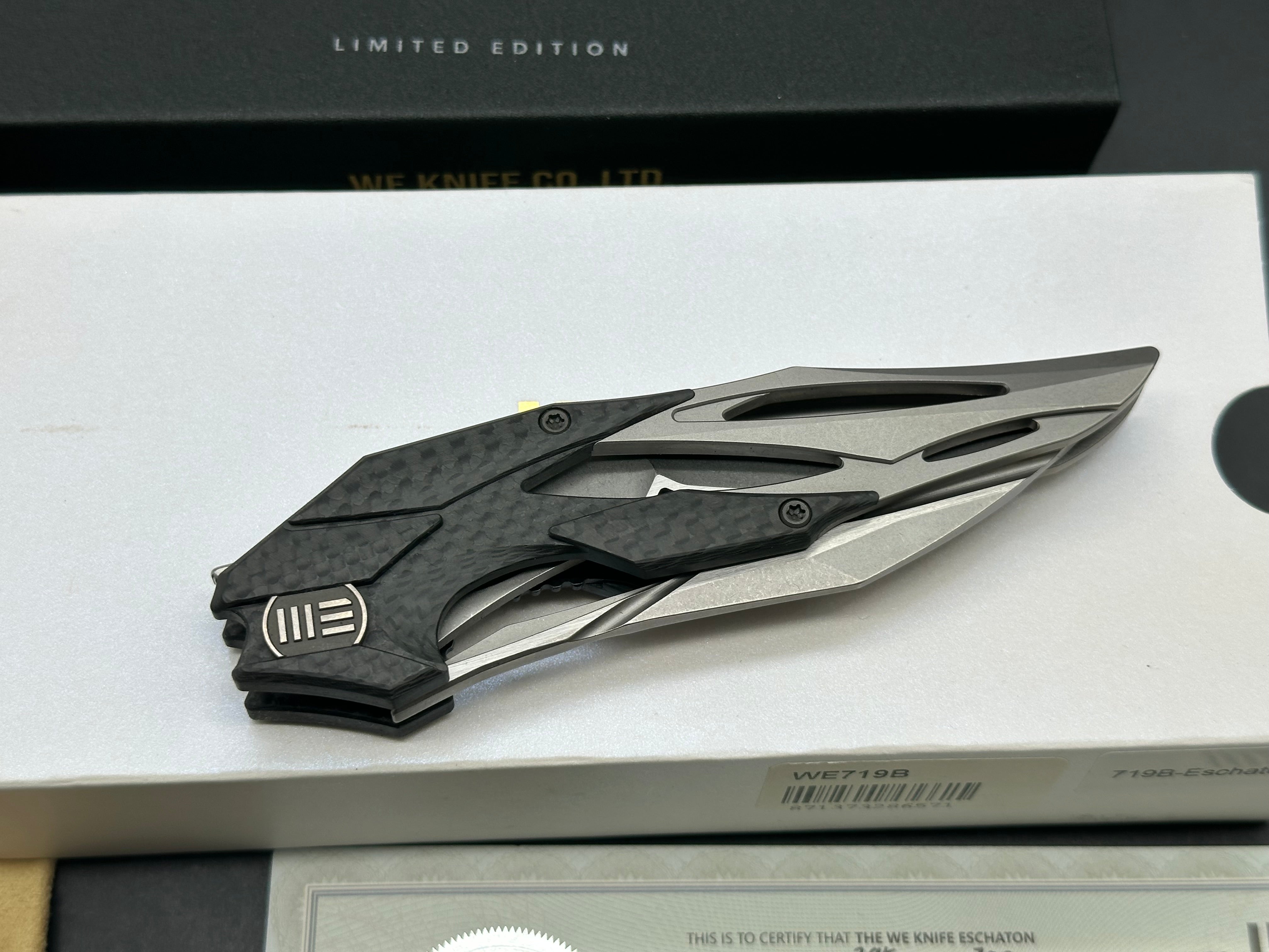 We Eschaton: Elijah Isham design. 3.83 inch, M390, flat grind wharncliffe blade Carbon fiber and titanium handle