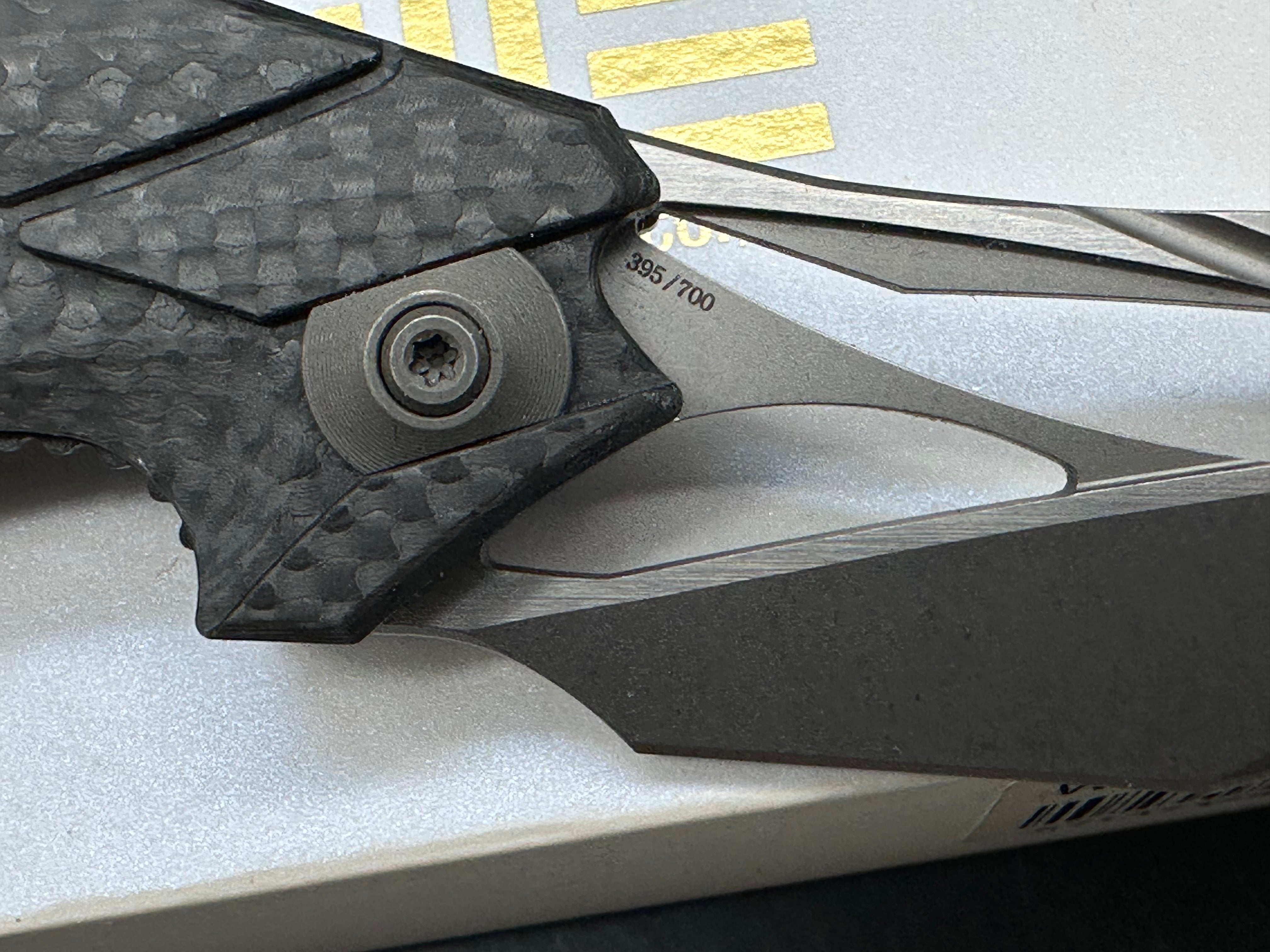 We Eschaton: Elijah Isham design. 3.83 inch, M390, flat grind wharncliffe blade Carbon fiber and titanium handle