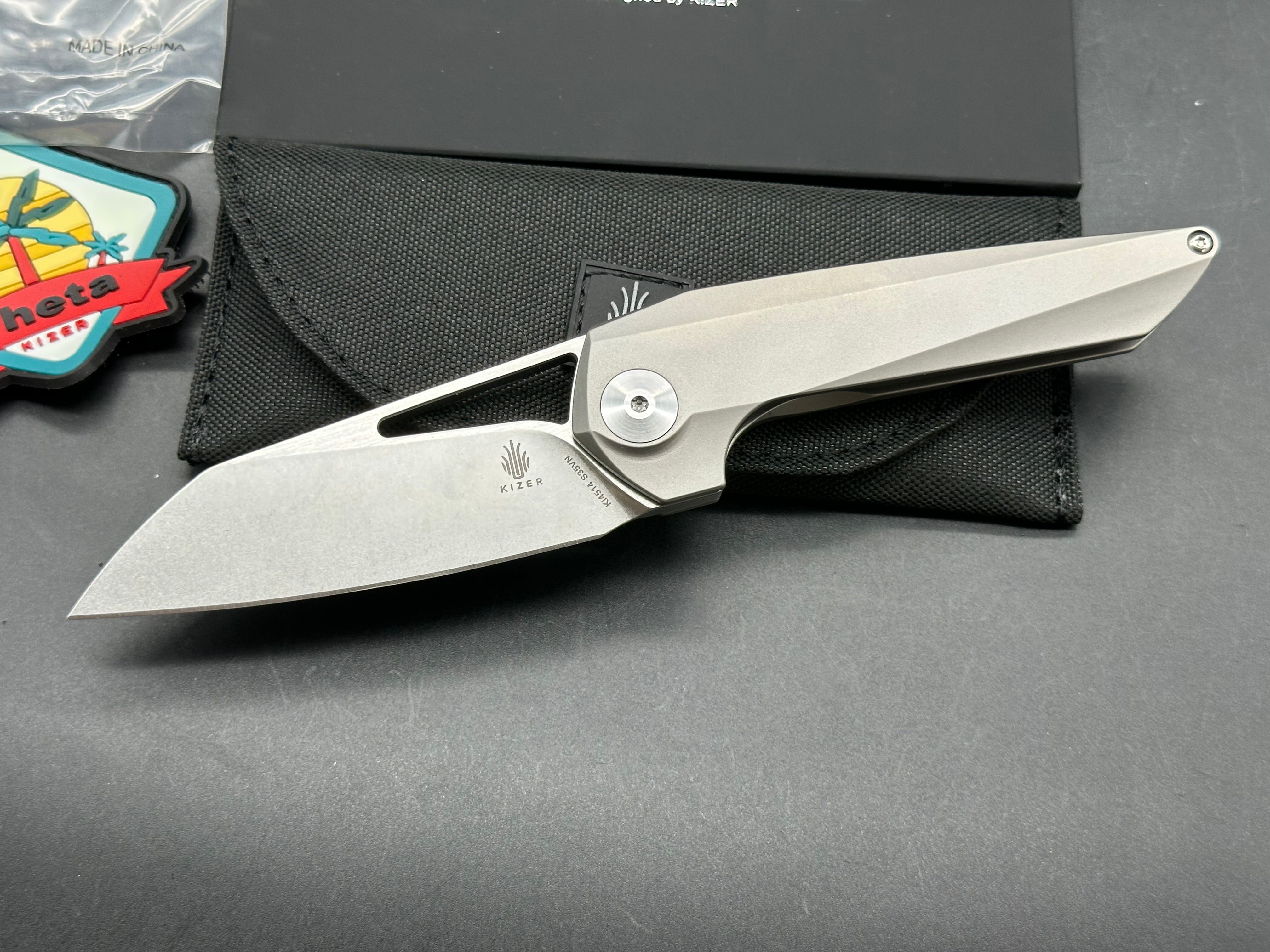 Kizer Theta: Elijah Isham design. 3.125 inch, stonewashed, flat grind, Wharncliffe CMP-S35V blade. Titanium handle
