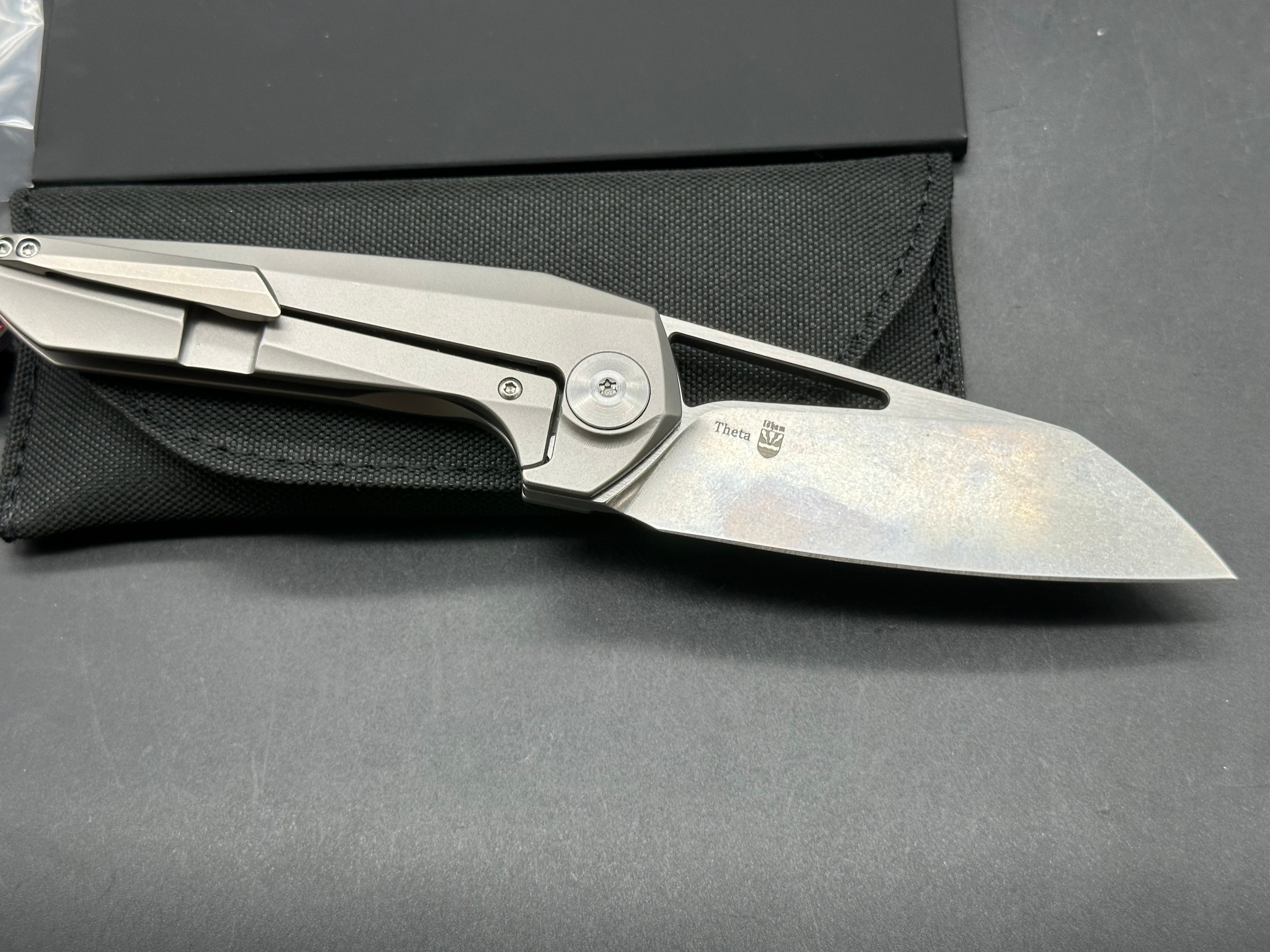 Kizer Theta: Elijah Isham design. 3.125 inch, stonewashed, flat grind, Wharncliffe CMP-S35V blade. Titanium handle
