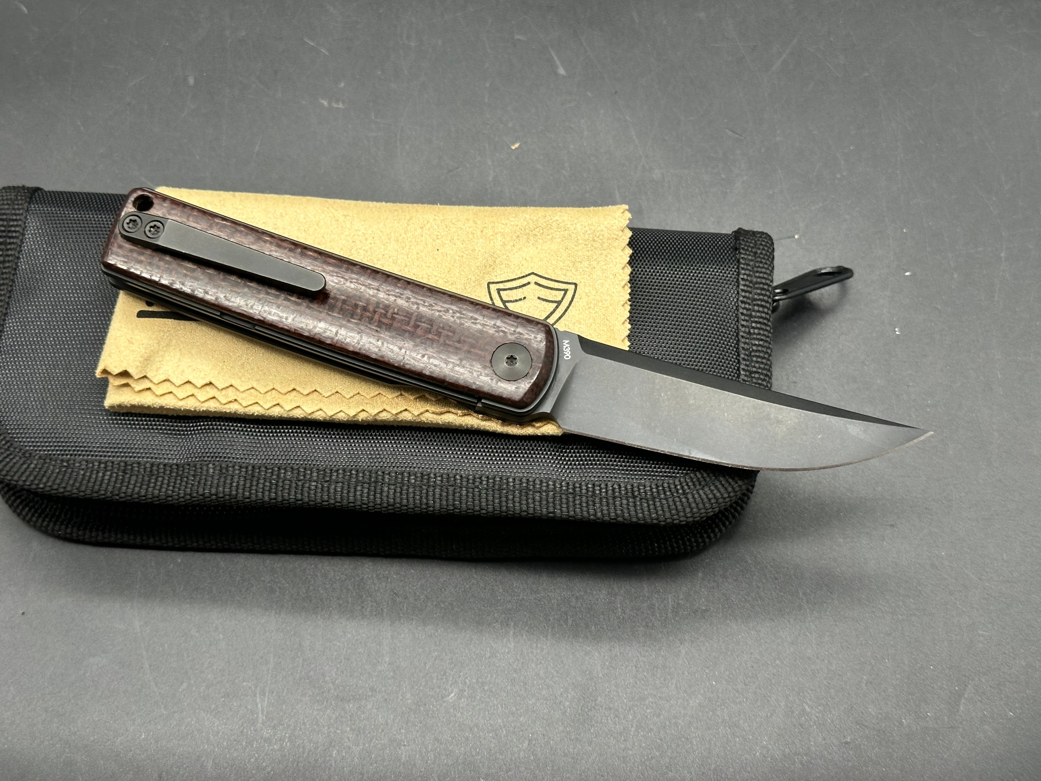 Reate Bushido: 3 inch trailing point, flat grind, blackwash, M390 blade. Front flipper. Blackwash titanium clip. Brown micarta handle
