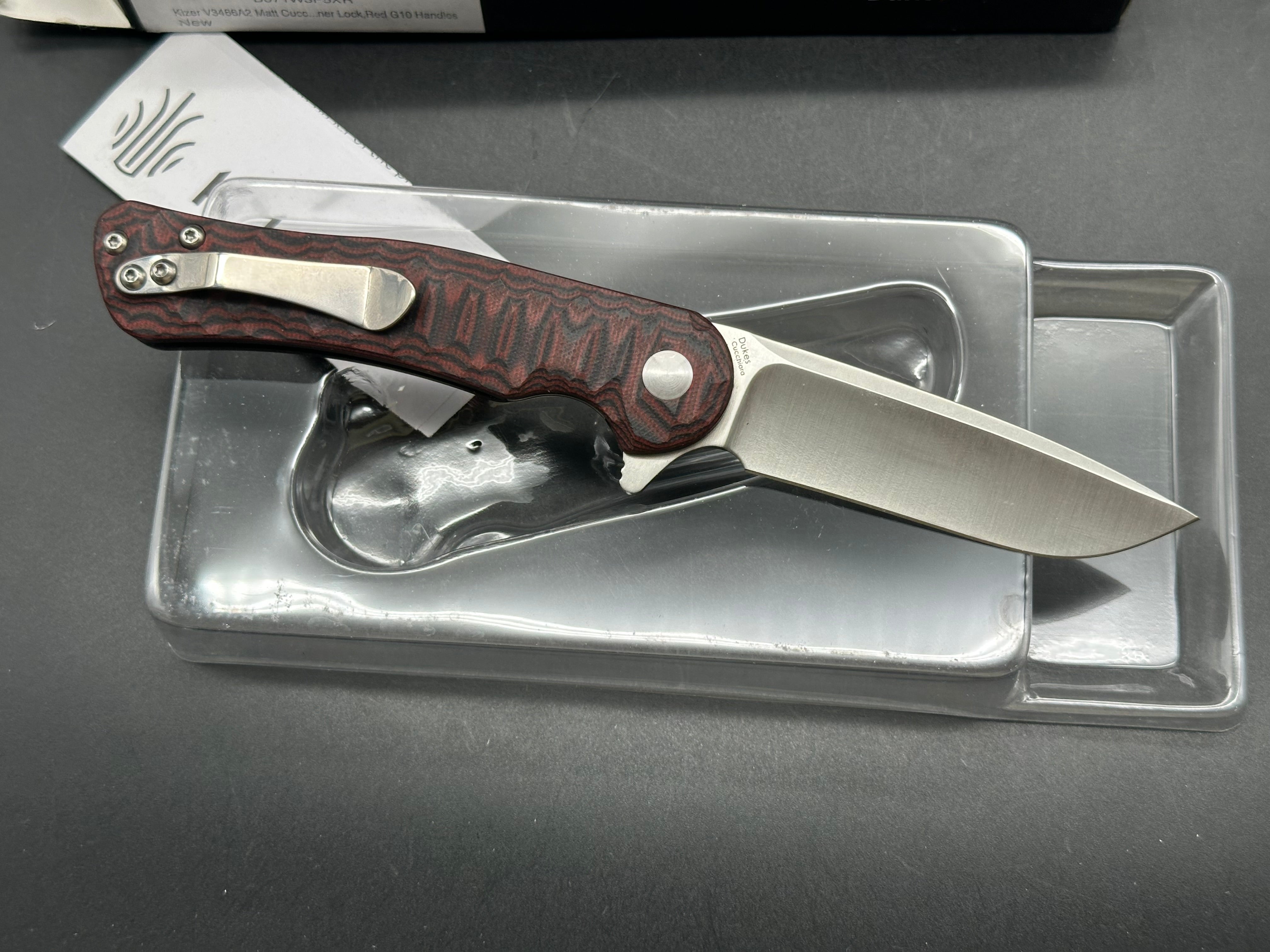 Kizer Dukes A2: Matt Cucchiara design. 3 inch drop point, hollow grind VG-10 blade. Red G-10 handle