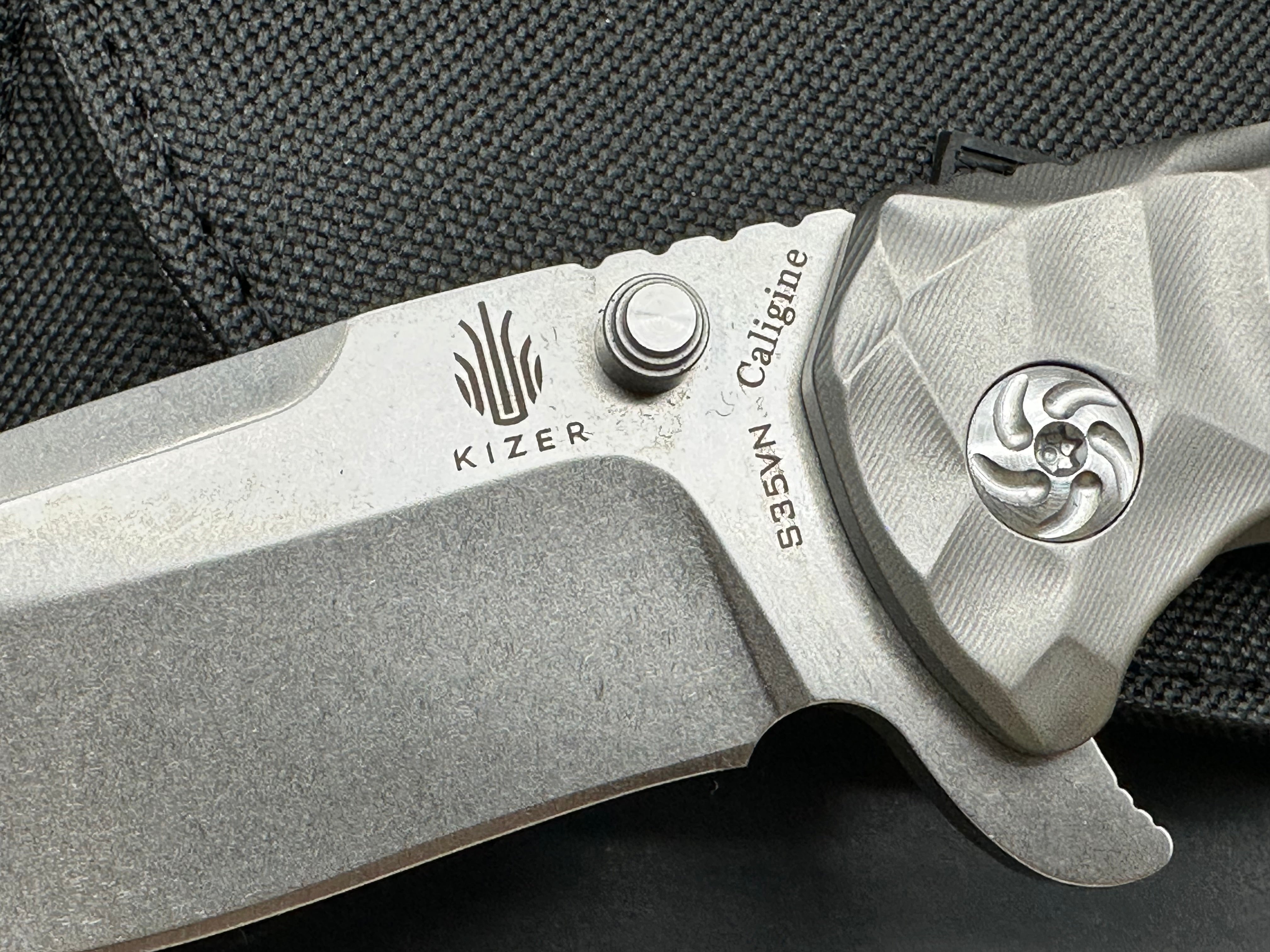 Kizer Caligine 3.58 inch stonewash, drop point, flat grind CPM-S35VN blade. Frame lock. Titanium handle. Titanium clip