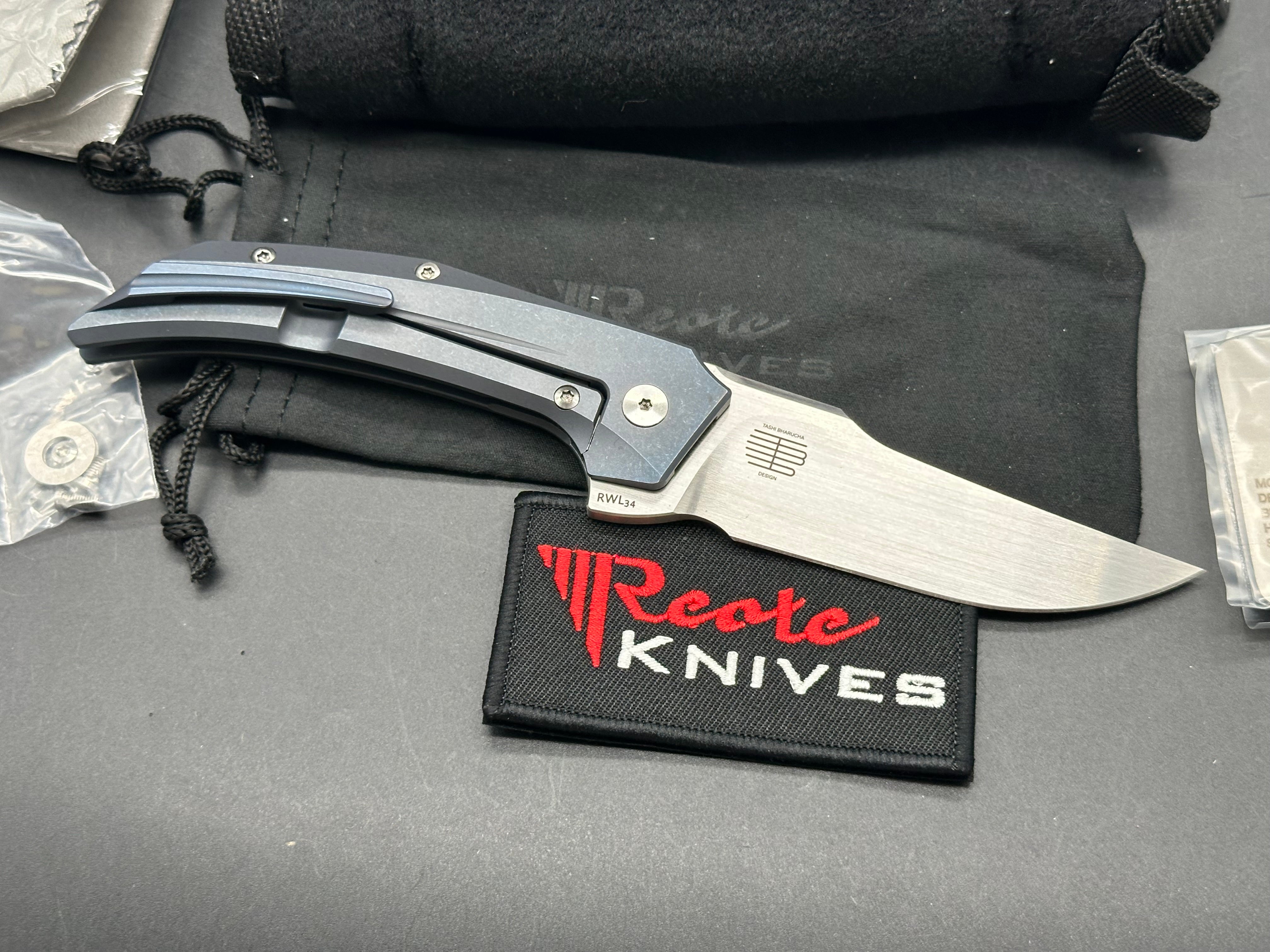 Reate Starboy: Tashi Bharucha design. 3 inch, hand rub, satin, clip point RWL-34 blade. Milled and blue anodized frame