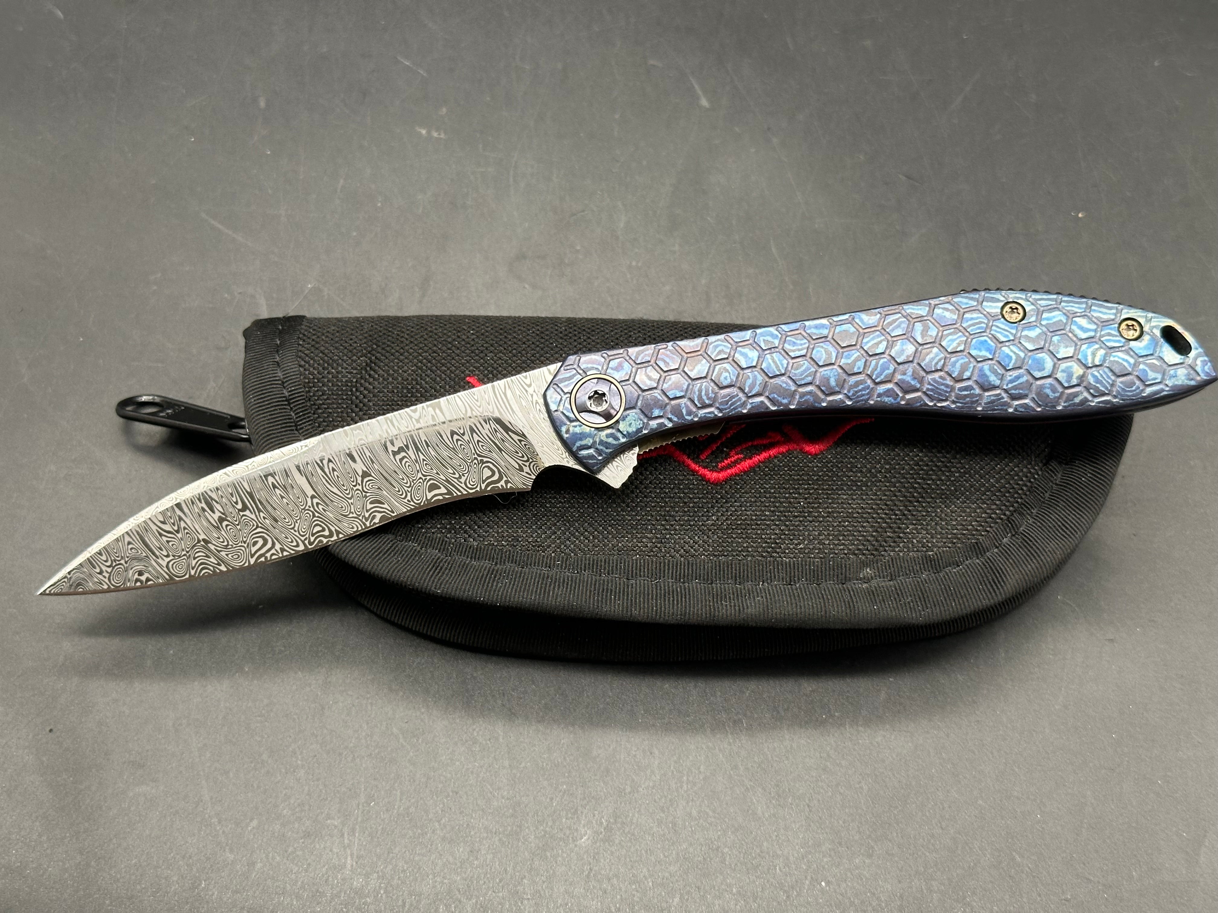 Jerry Moen Mongoose: 3.5 inch Damasteel recurve blade. Milled Mokuti frame with anodized titanium backspacer and clip