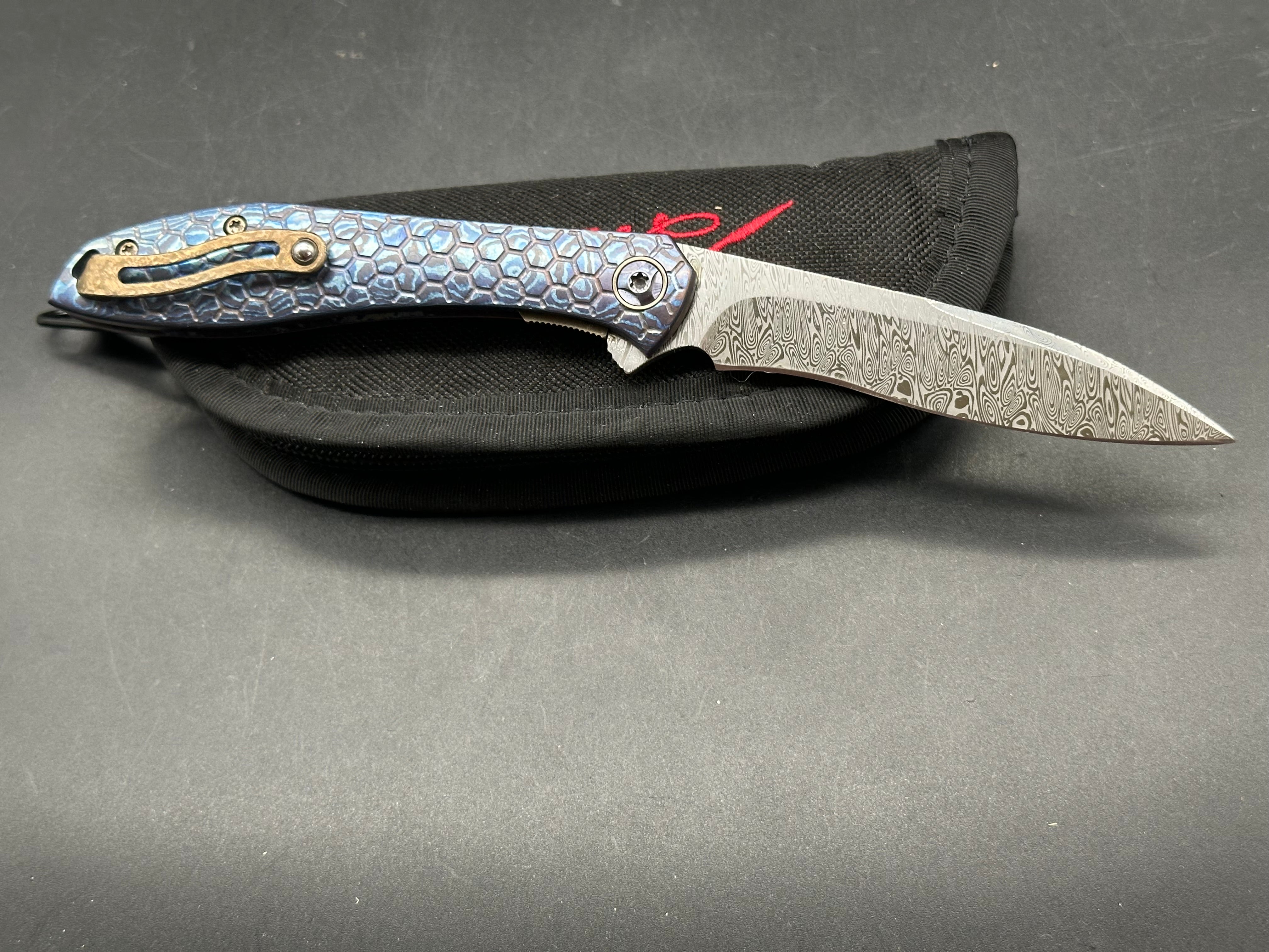 Jerry Moen Mongoose: 3.5 inch Damasteel recurve blade. Milled Mokuti frame with anodized titanium backspacer and clip