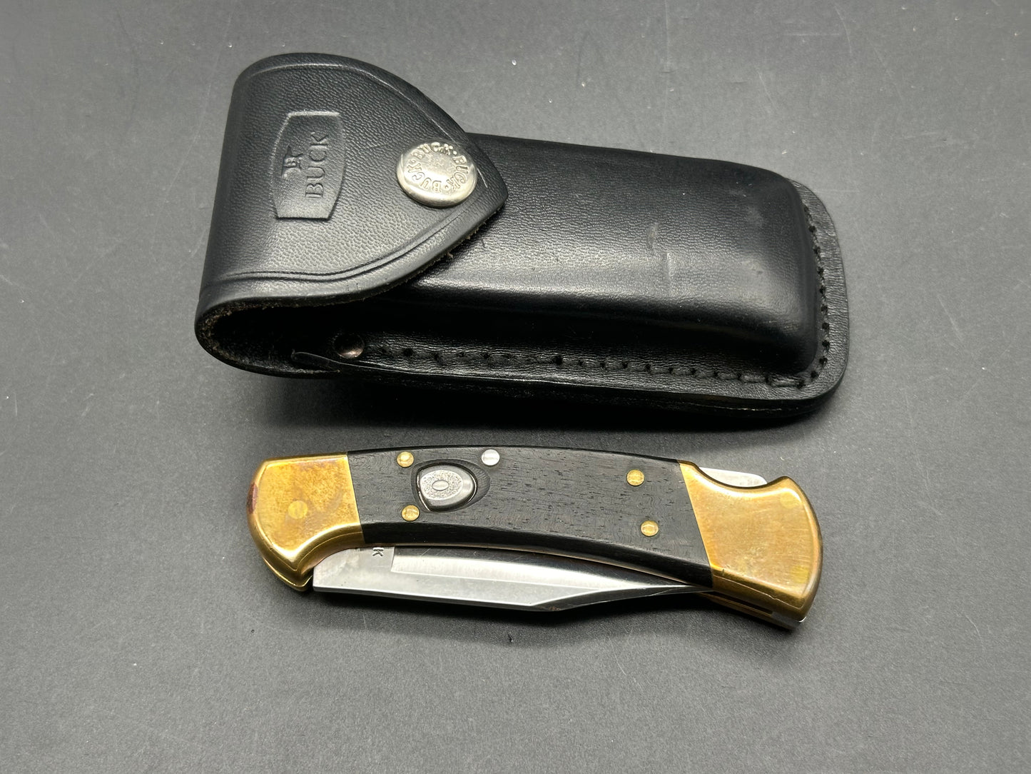 Buck 110 auto used with leather belt carrying pouch