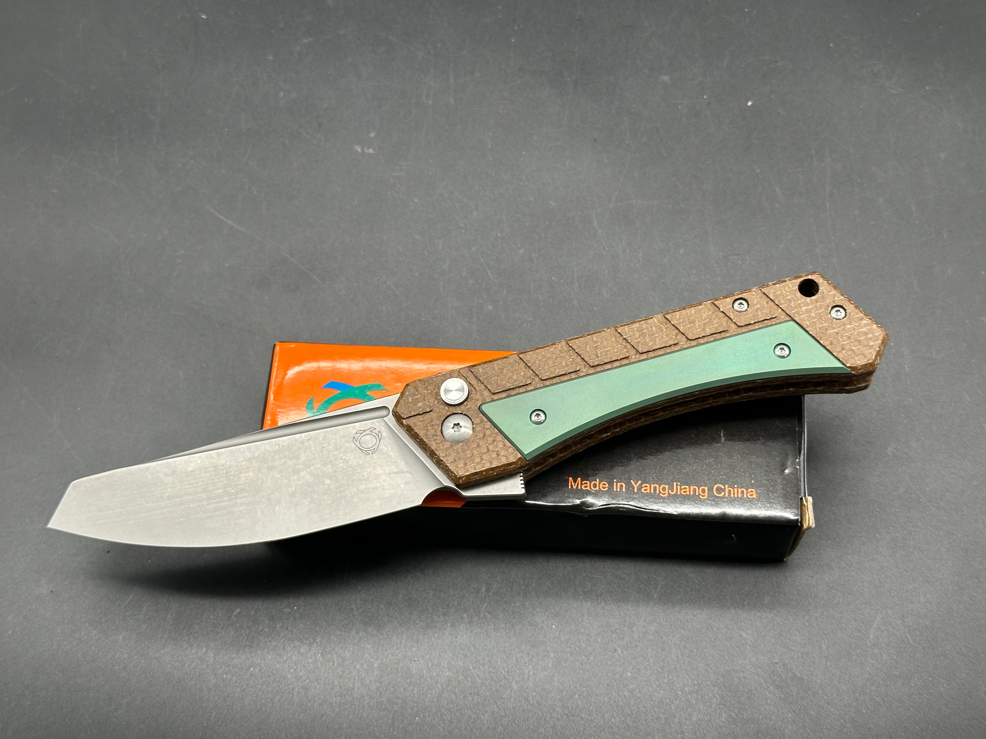 Sixleaf SL-22 GR  Rattlesnake design, button lock, micarta scales with green titanium inserts and pocket clip, 154-CM blade