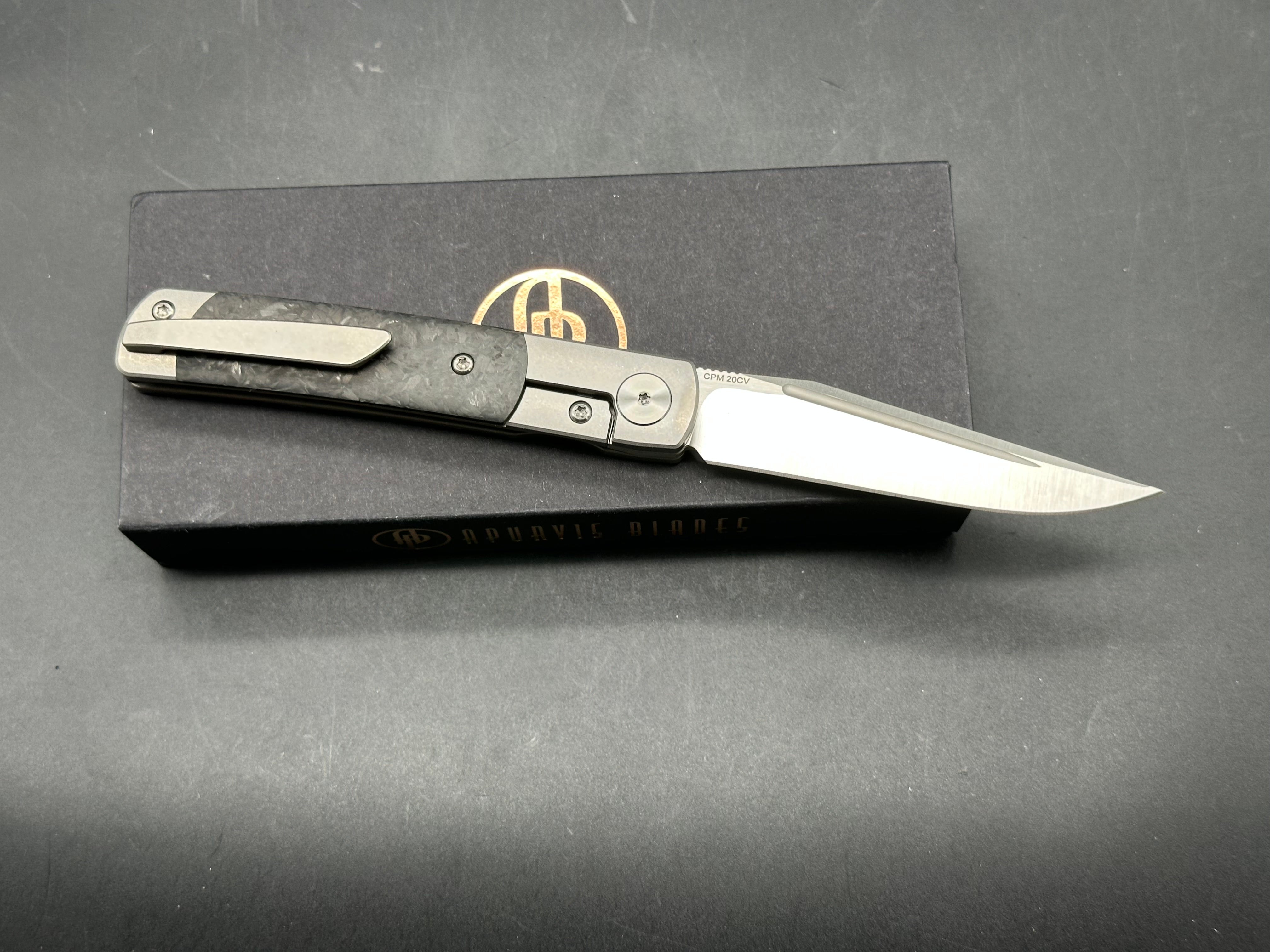 Adam Purvis Rook 3.3 inch vertical belt sanded CPM-20CV blade. Titaniu scales with marbled carbon fiber inlays. Satin hardware