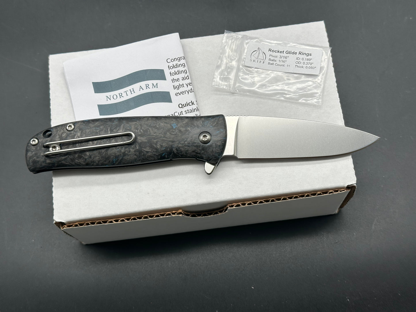 North Arm Skaha II, 3.34” Polished Stonewash MagnaCut Drop Point Blade with Blue Dark Matter Fat Carbon Handle (Serial #3154)