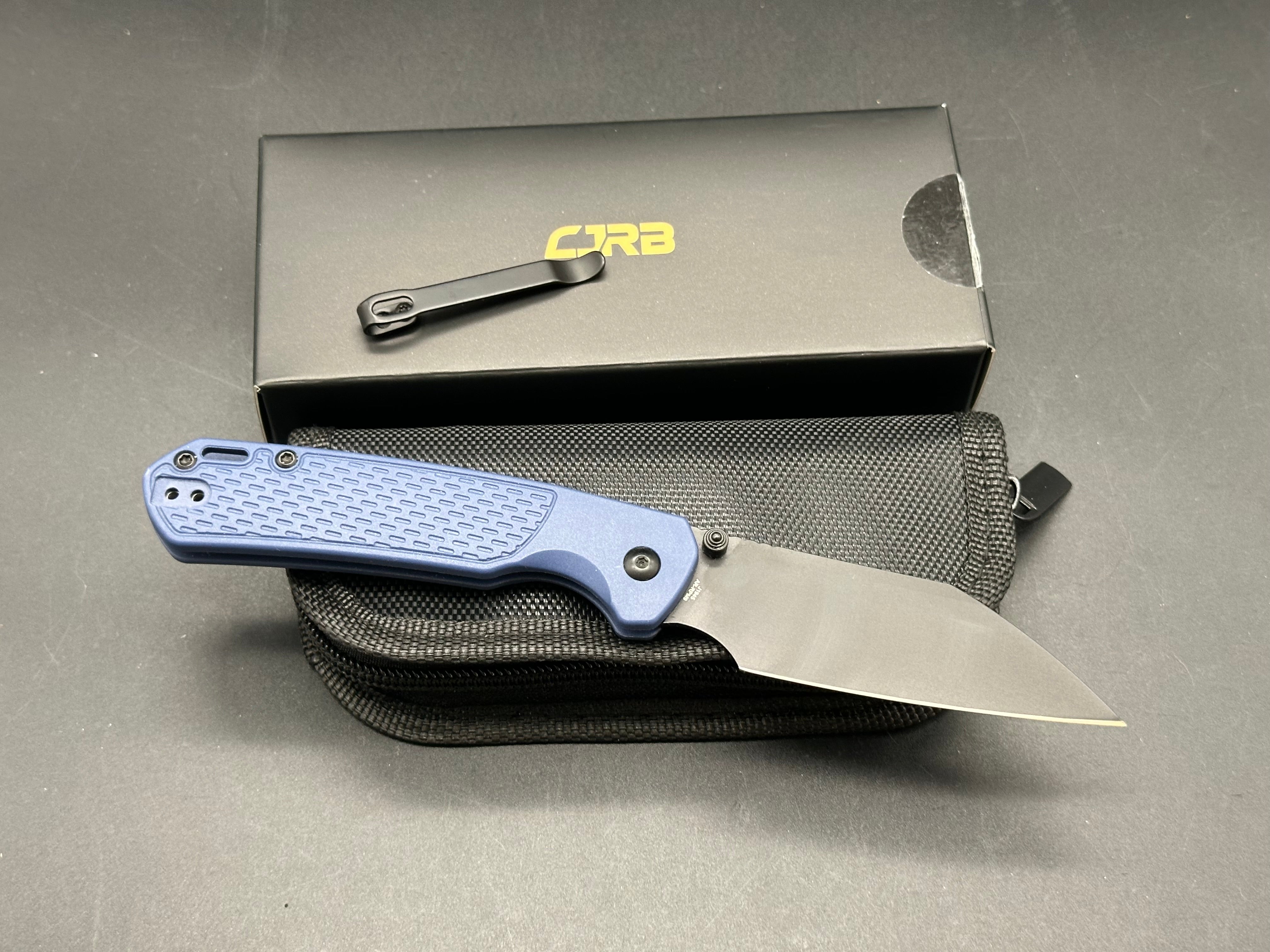 CJRB Pyrite-Light Button Lock/Thumb Stud Blue FRN scales with blue titanium pocket clip (3.34" AR-RPM9 Black PVD Wharncliffe)