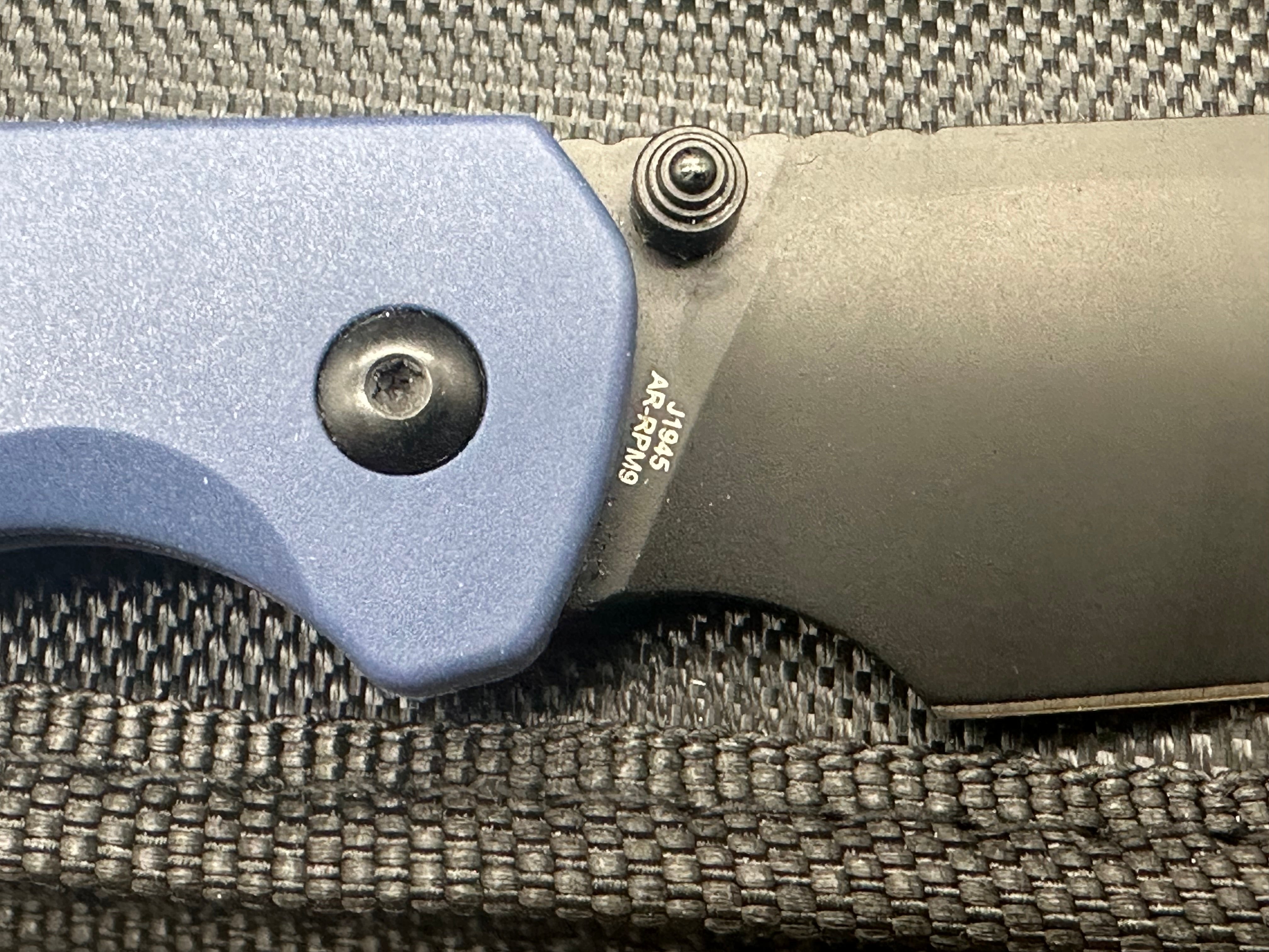 CJRB Pyrite-Light Button Lock/Thumb Stud Blue FRN scales with blue titanium pocket clip (3.34" AR-RPM9 Black PVD Wharncliffe)