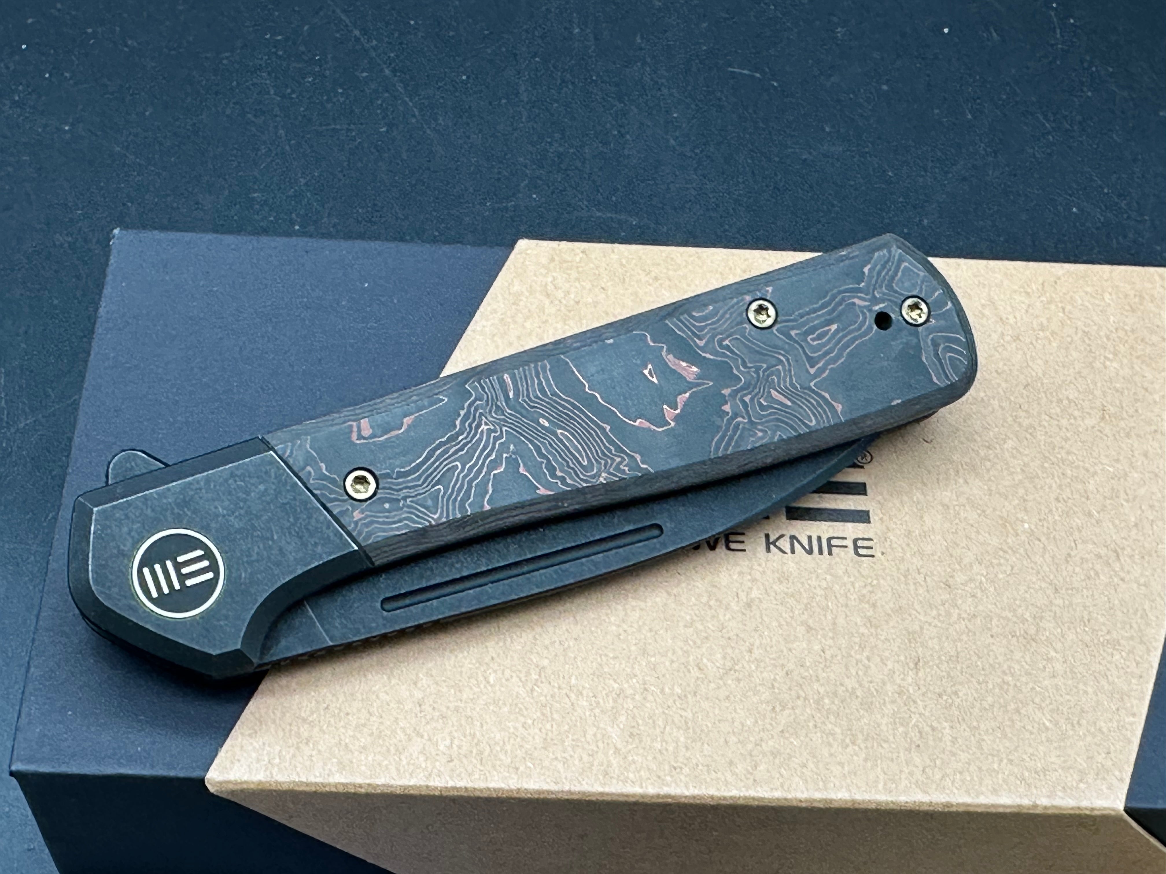 WE SOOTHSAYER FOLDING KNIFE BLACK TITANIUM/COPPER FOIL CARBON FIBER INLAY HANDLE 20CV DROP POINT PLAIN EDGE