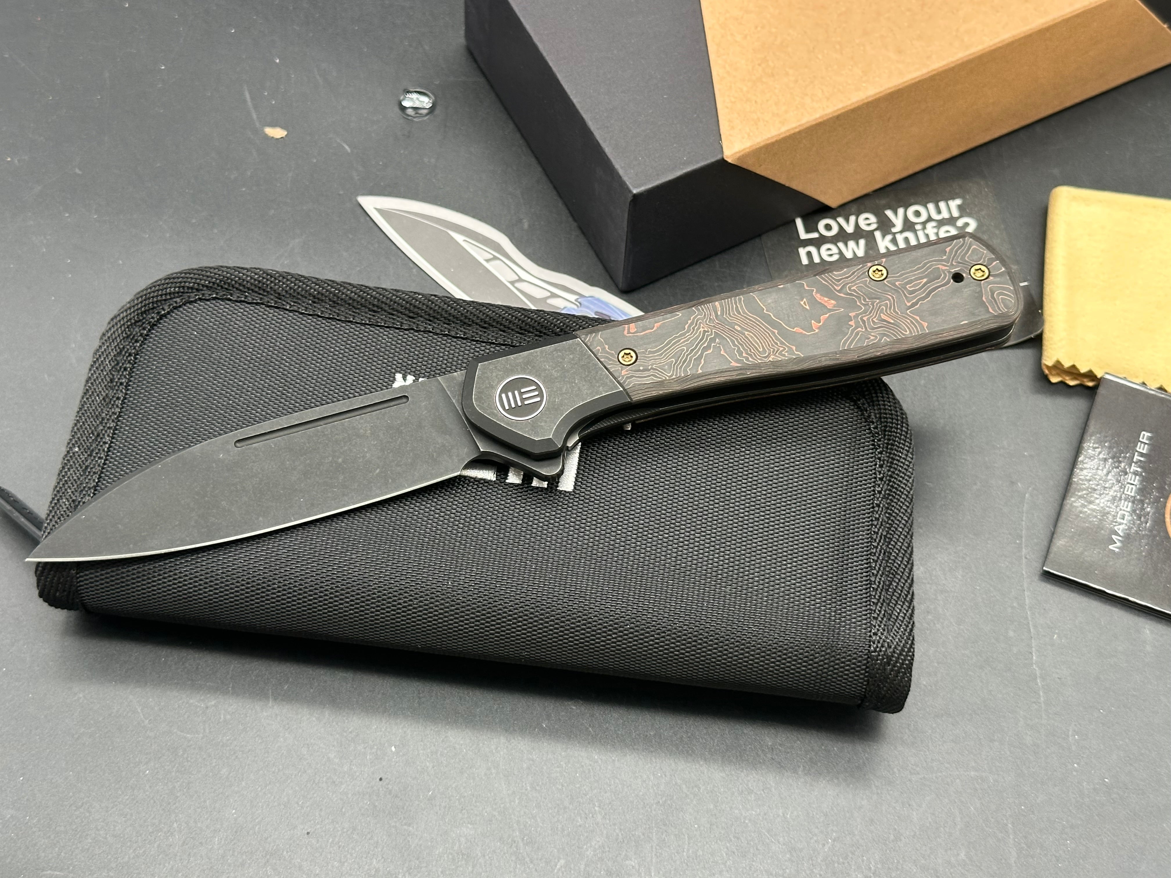 WE SOOTHSAYER FOLDING KNIFE BLACK TITANIUM/COPPER FOIL CARBON FIBER INLAY HANDLE 20CV DROP POINT PLAIN EDGE