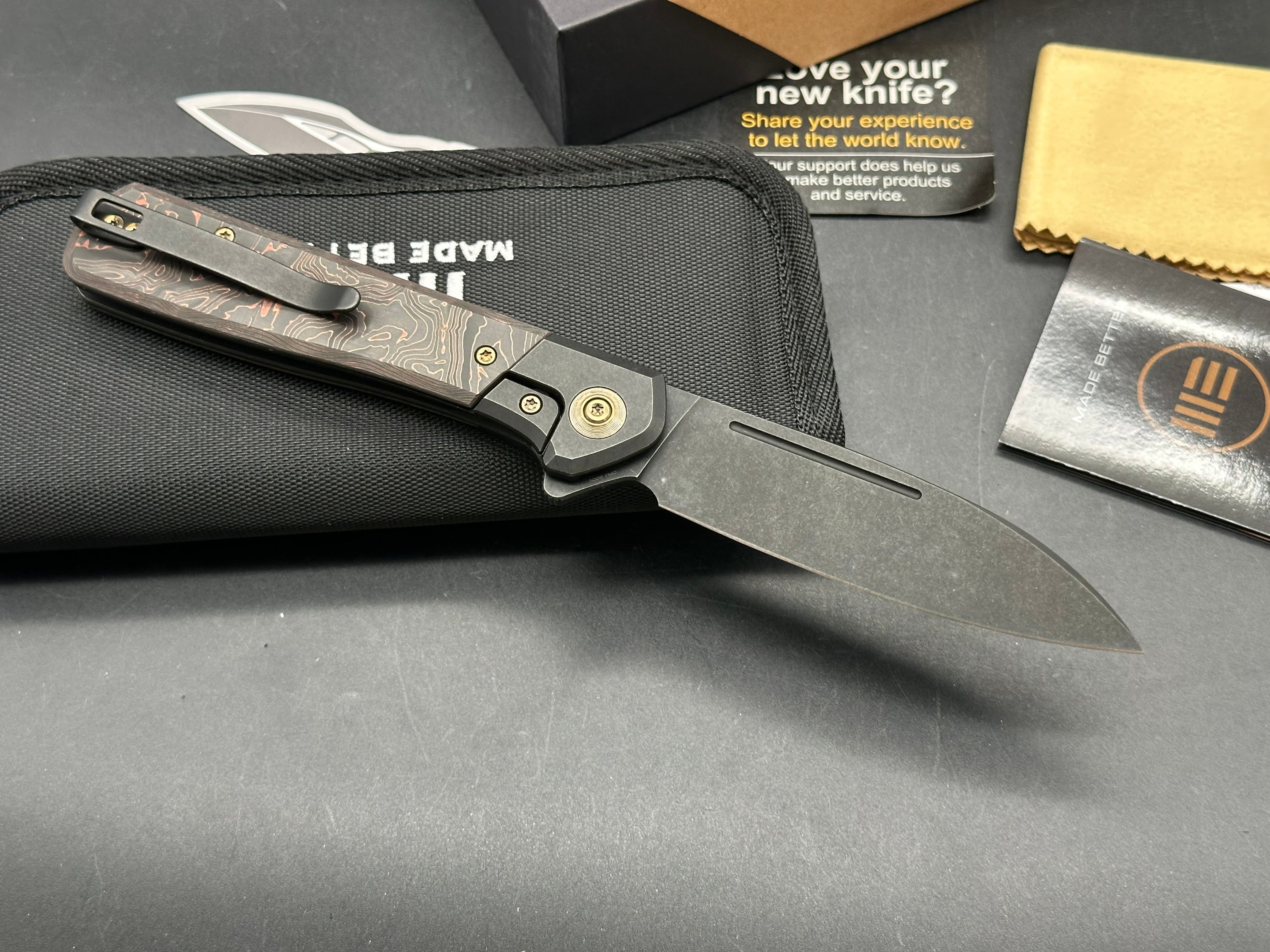 WE SOOTHSAYER FOLDING KNIFE BLACK TITANIUM/COPPER FOIL CARBON FIBER INLAY HANDLE 20CV DROP POINT PLAIN EDGE