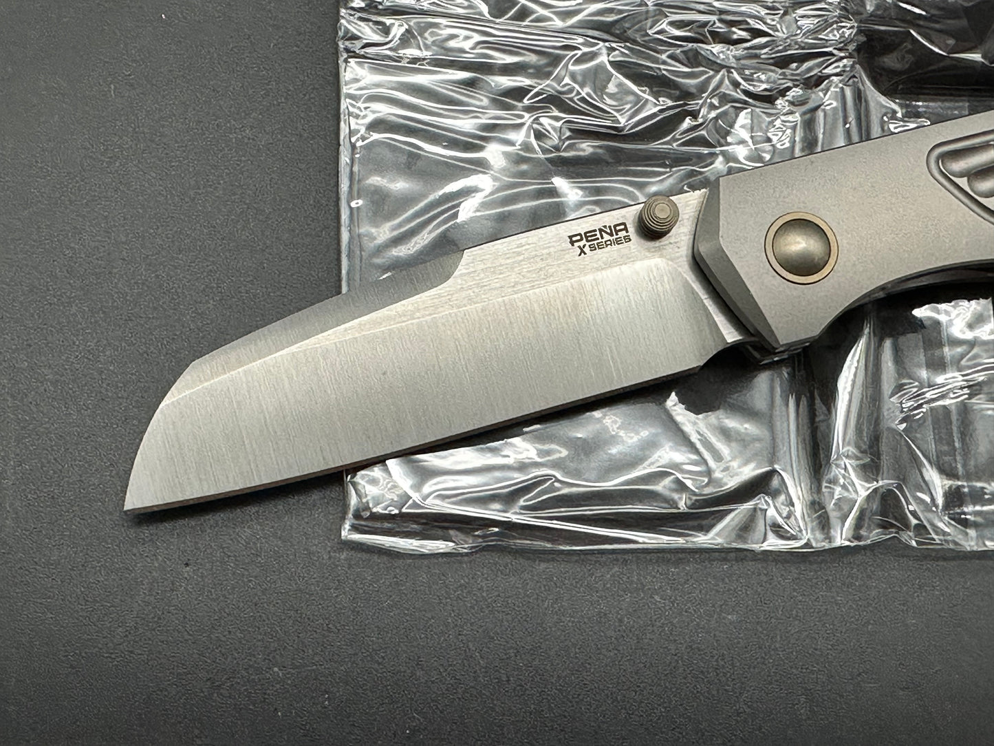 Pena X-Series Bravo 1, Belt Satin M390 Blade, Jigged Titanium Handles