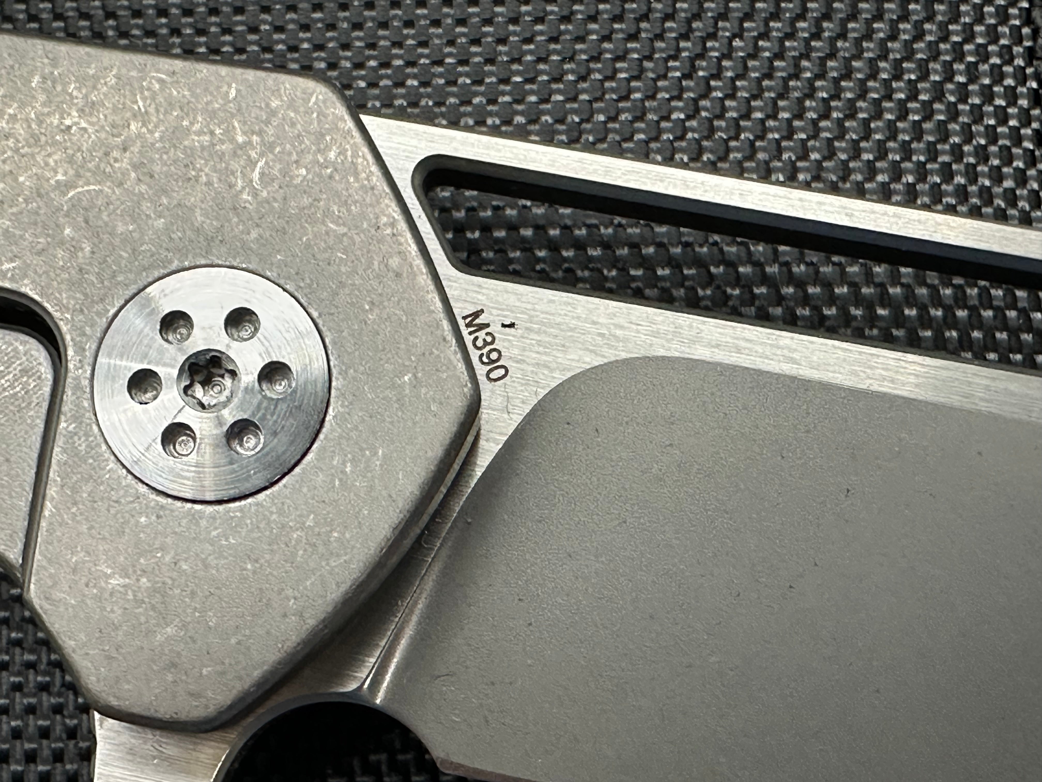 A. Purvis Blades Primordial MK2, Stonewashed M390 Blade Titanium Handles with Marbled Carbon Fiber Overlays