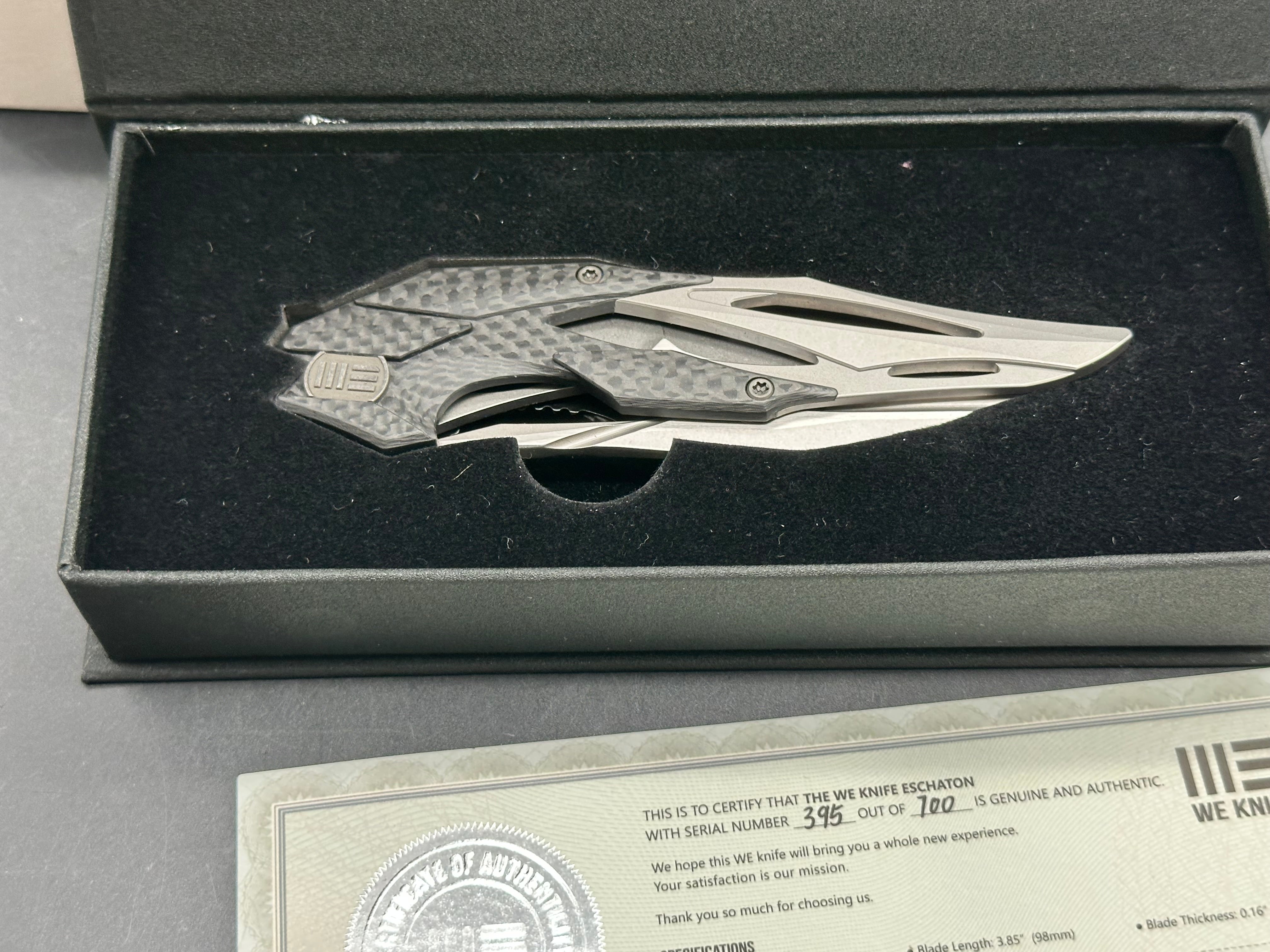 We Eschaton: Elijah Isham design. 3.83 inch, M390, flat grind wharncliffe blade Carbon fiber and titanium handle