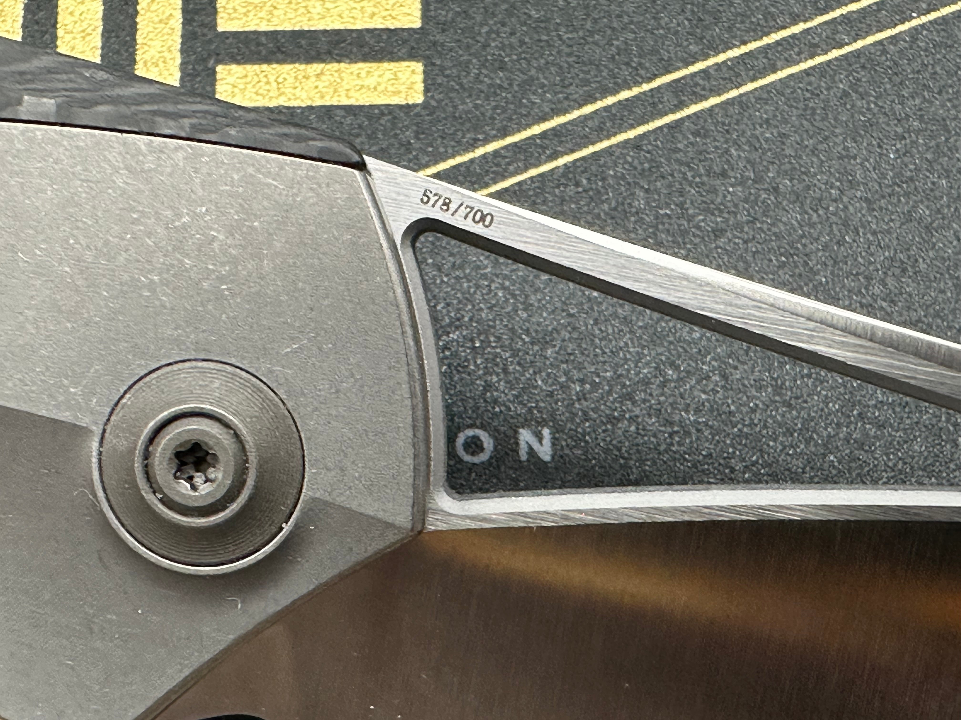 We Zeta: Elijah Isham design. 3.875 inch M390, trailing point, flat grind, satin finish blade. Frame lock. Carbon fiber and titanium handle