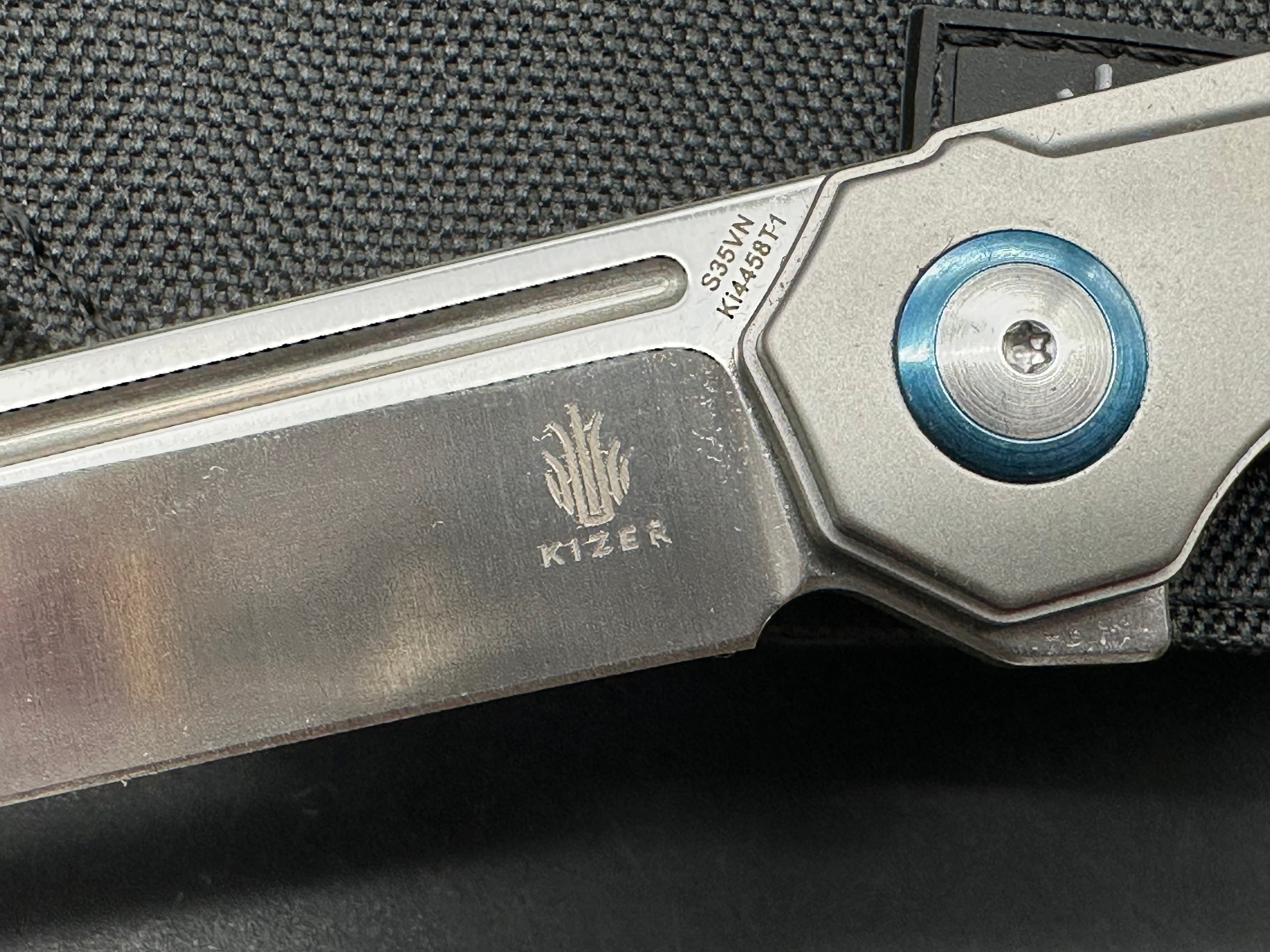 Kizer Begleiter: Azo design. 3.5 inch hollow grind CPM-S35V tanto blade. Titanium handle with anodized blue pivot