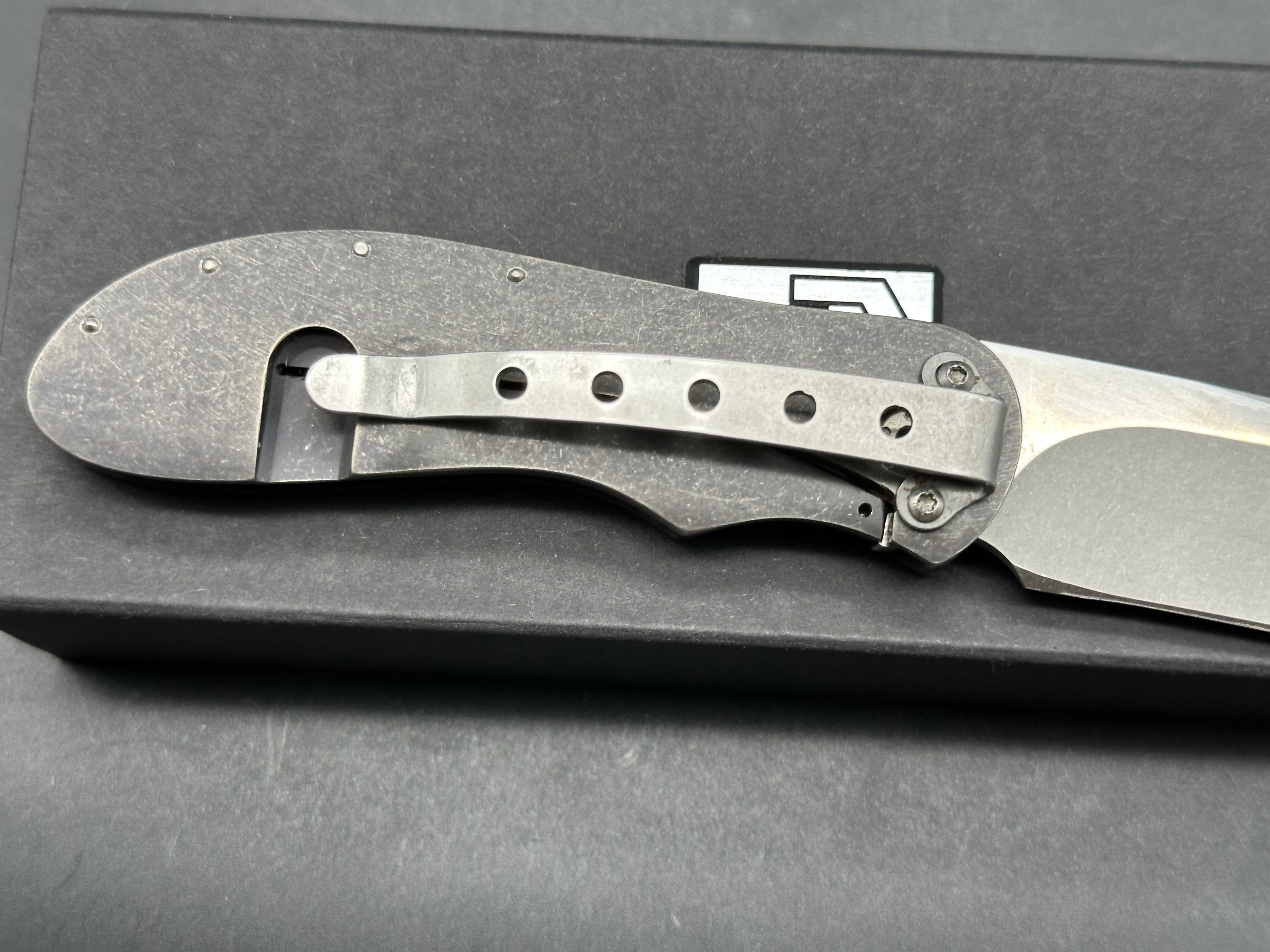 JD Van Deventer EDC Front Flipper 2.75 inch drop point, stone washed two tone N690 blade. Acid tumble titanium frame with carbon fiber handle