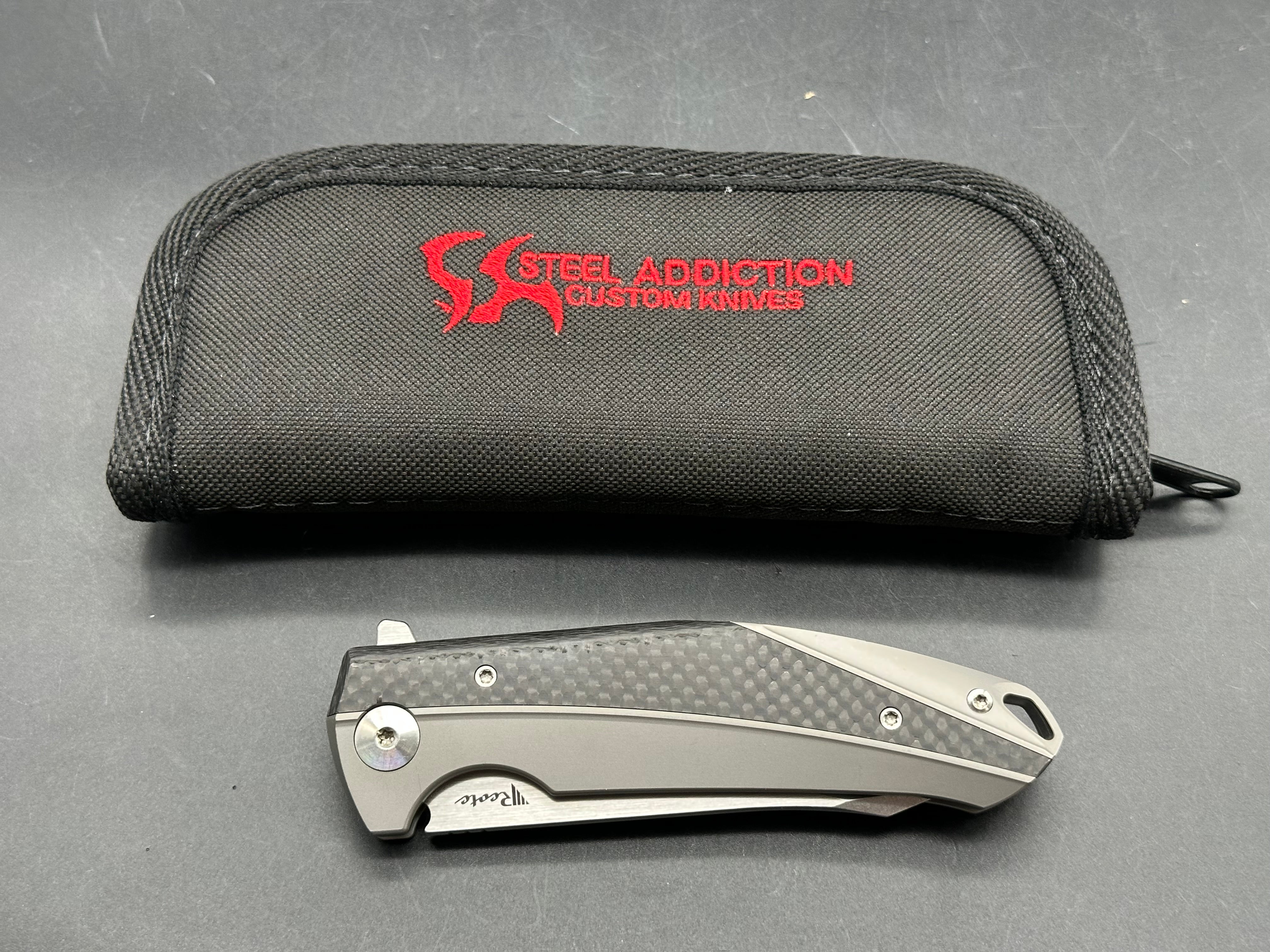 Reate K1: 3.875 inch RWL-34 blade. Steel overtravel stop. Titanium and carbon fiber handle