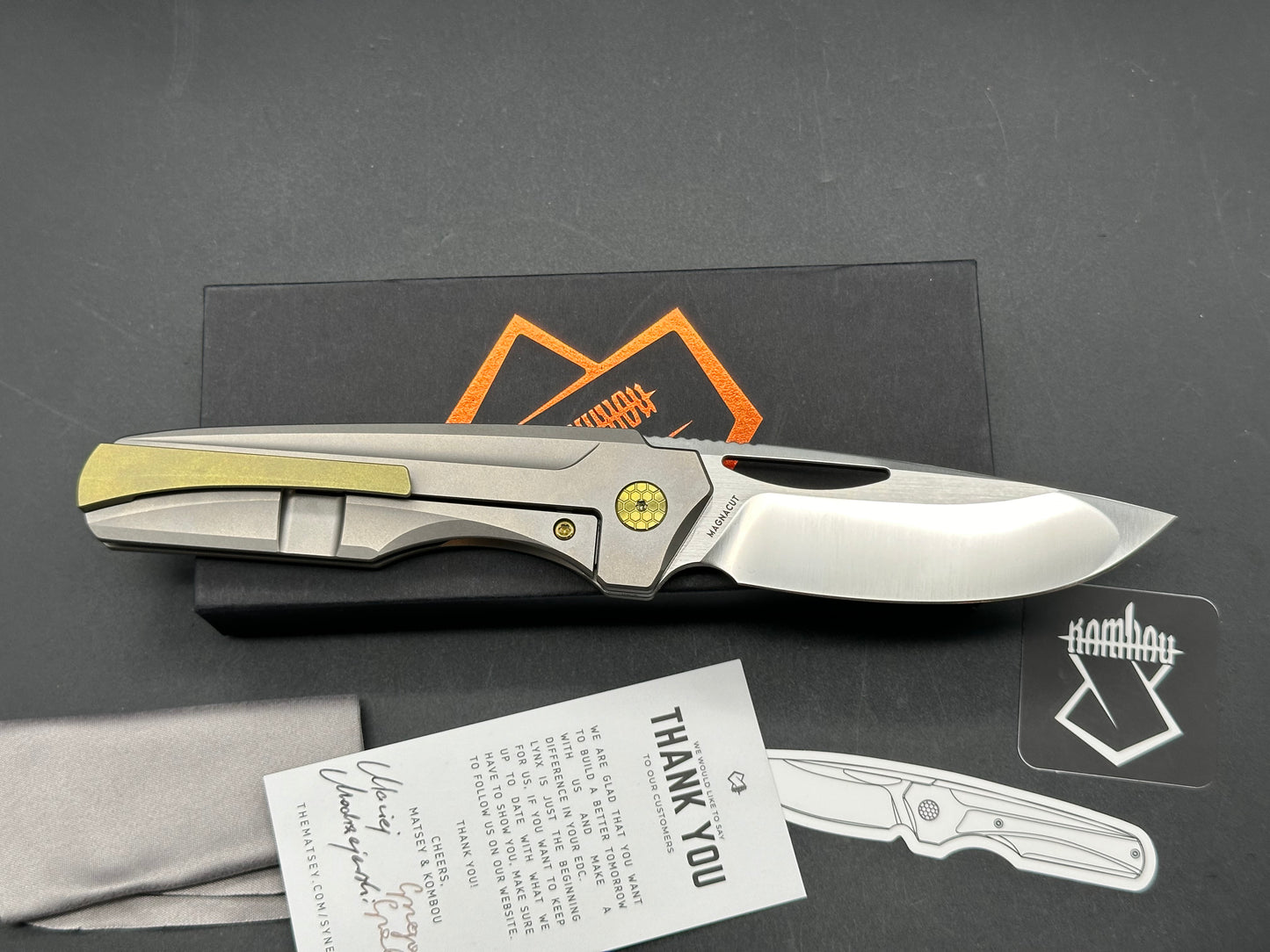 The Matsey + Kombou Lynx Grey Ti Handle + Gold Marble CF w/ Gold Ano Accents/Drop Point/Satin Mangnacut