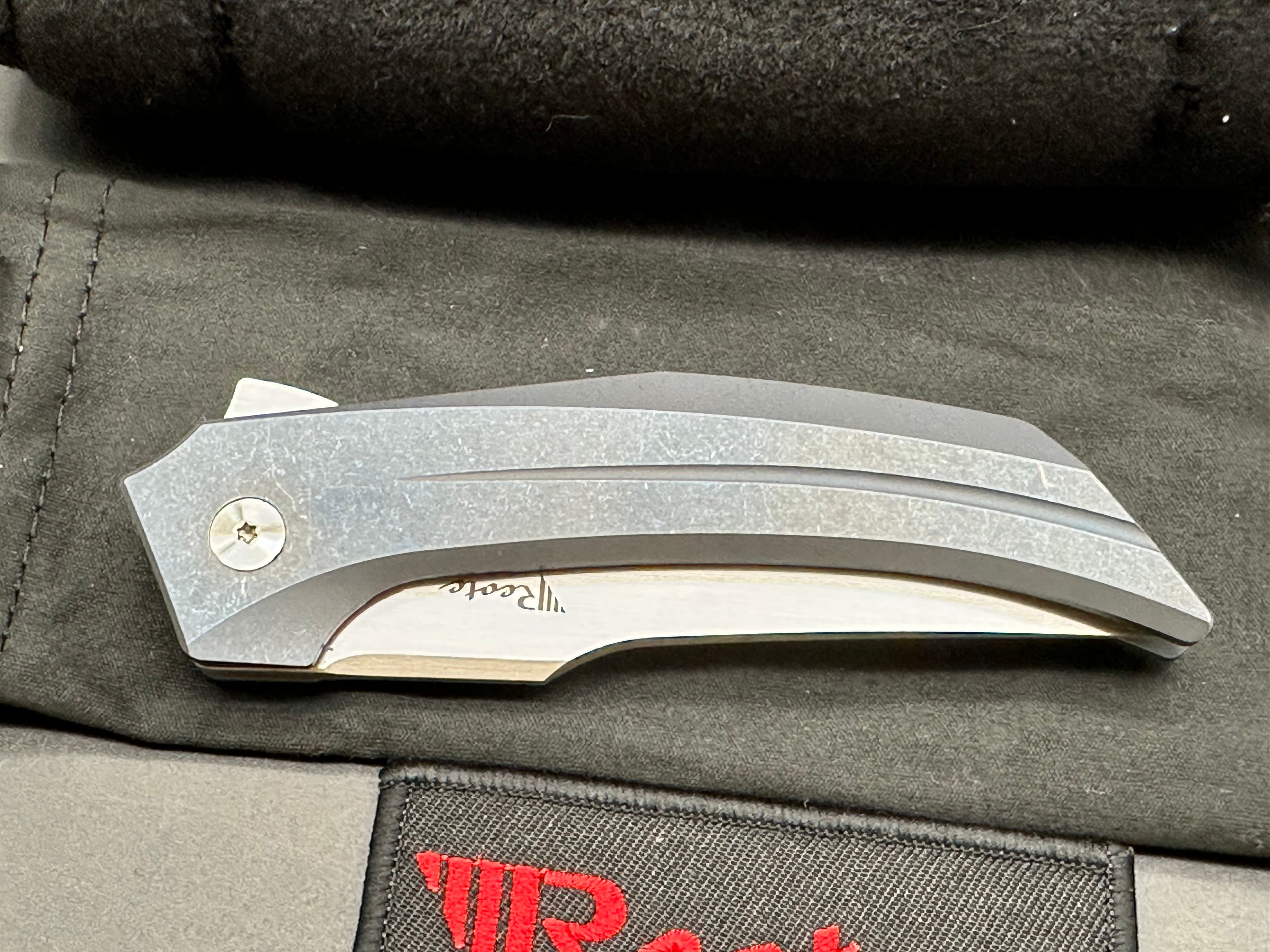 Reate Starboy: Tashi Bharucha design. 3 inch, hand rub, satin, clip point RWL-34 blade. Milled and blue anodized frame