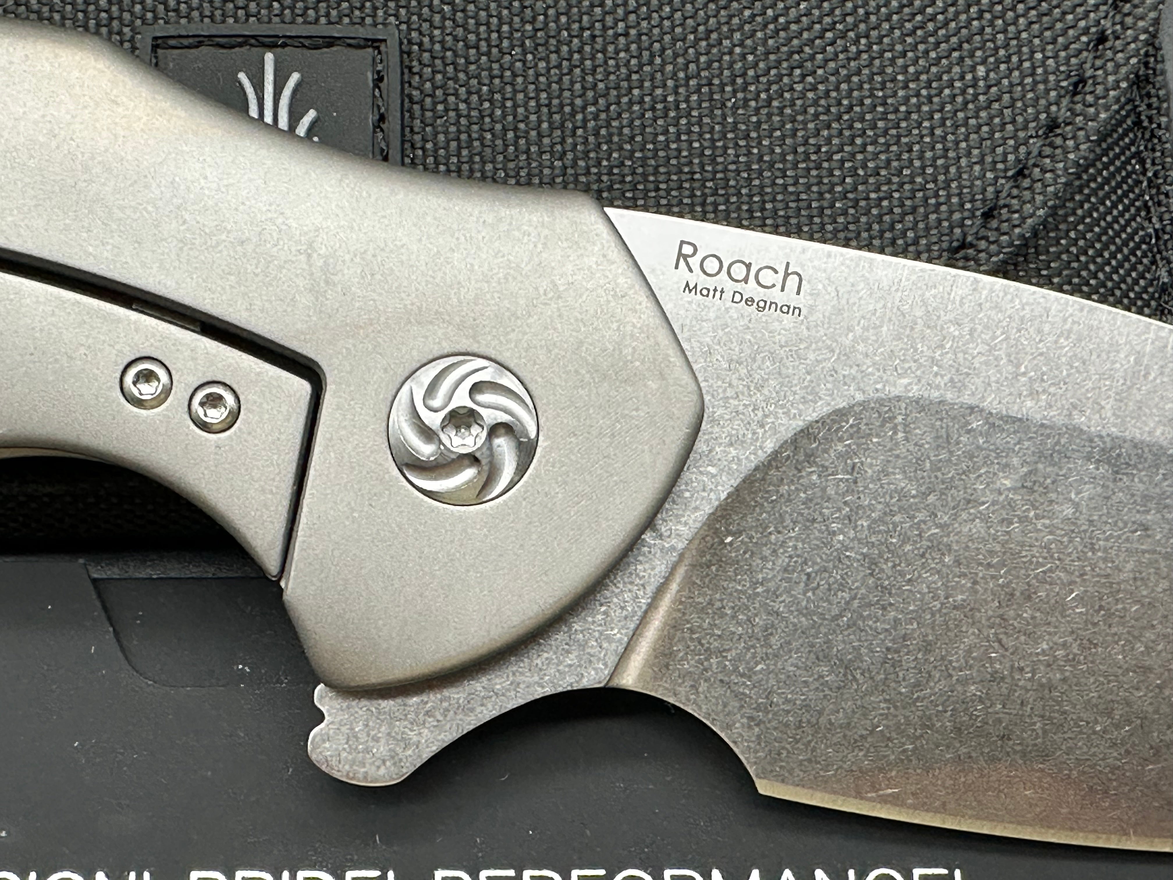 Kizer Roach Matt Degnan design 3.5 inch drop point flat grind, satin CPM-S35VN blade Titanium scales and clip with Roach insignia