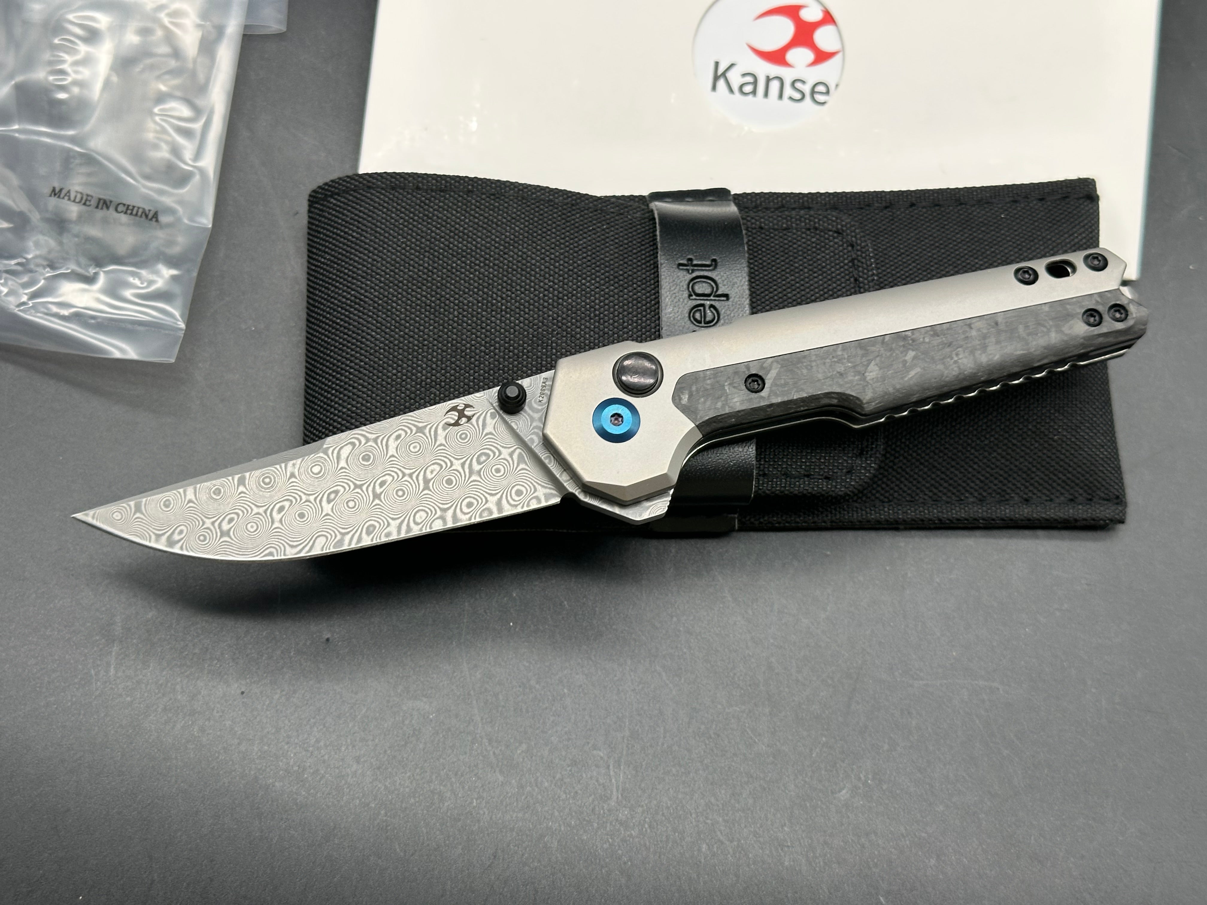 Kansept EDC Tac: Mikkel Willumsen design. 3.1 inch flat grind Damascus blade. Carbon fiber and titanium front and back scales