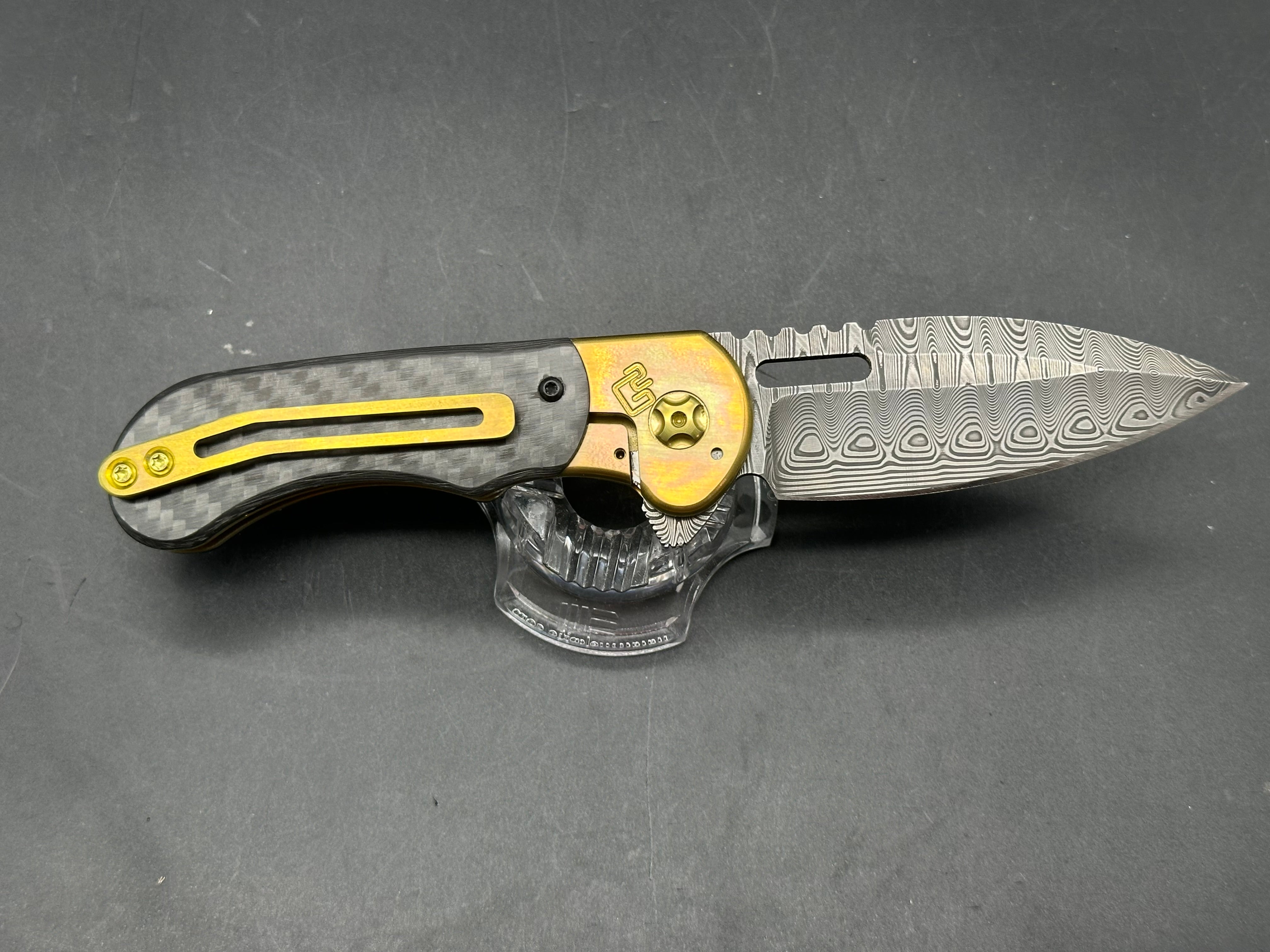 Quest Knives Gent's Spearpoint: 3.125 inch Odin's Eye Damascus blade. Anodized milled titanium frame with carbon fiber inserts