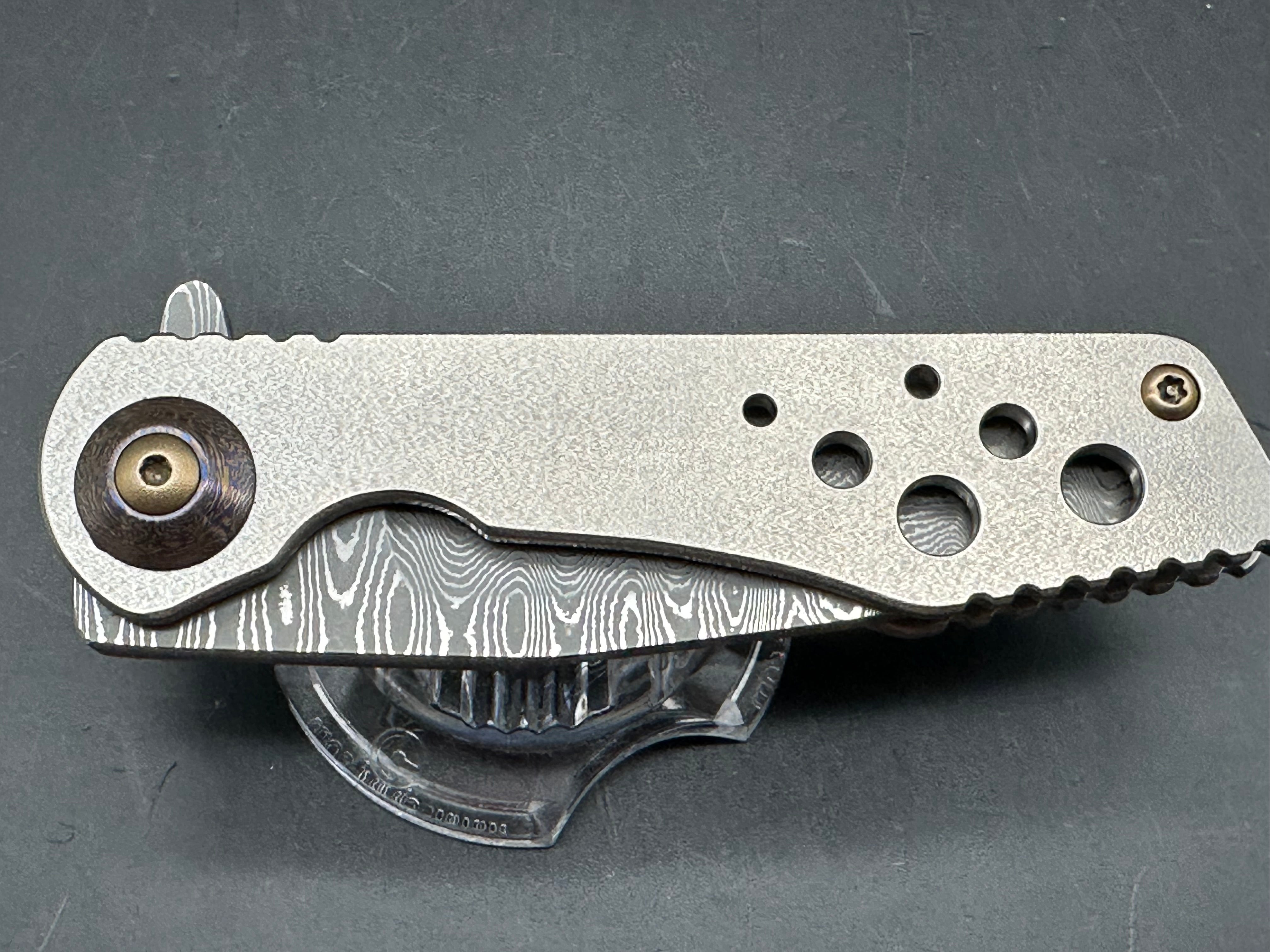 Jurgen Schanz Dress Flipper One-Off: 3.625 inch Damscus blade. Orange peel titanium frame. Mokuti pivot collars