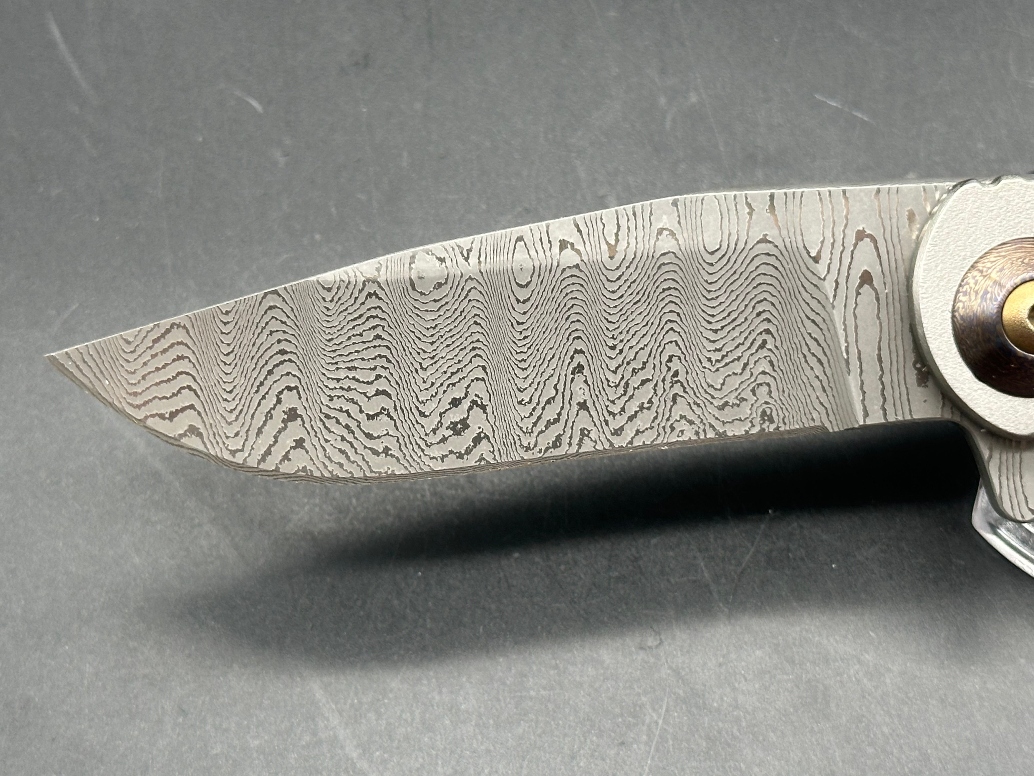 Jurgen Schanz Dress Flipper One-Off: 3.625 inch Damscus blade. Orange peel titanium frame. Mokuti pivot collars