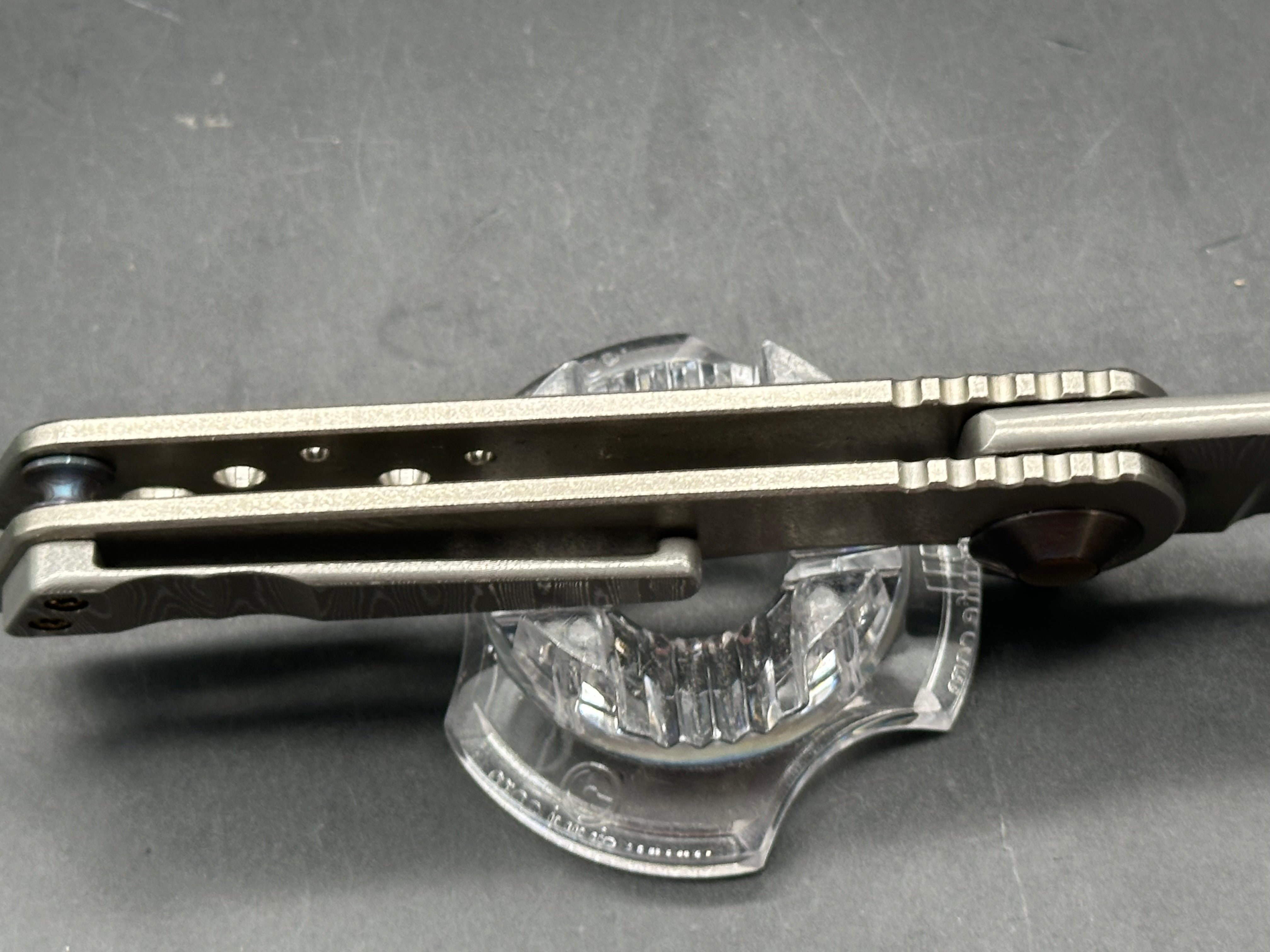 Jurgen Schanz Dress Flipper One-Off: 3.625 inch Damscus blade. Orange peel titanium frame. Mokuti pivot collars