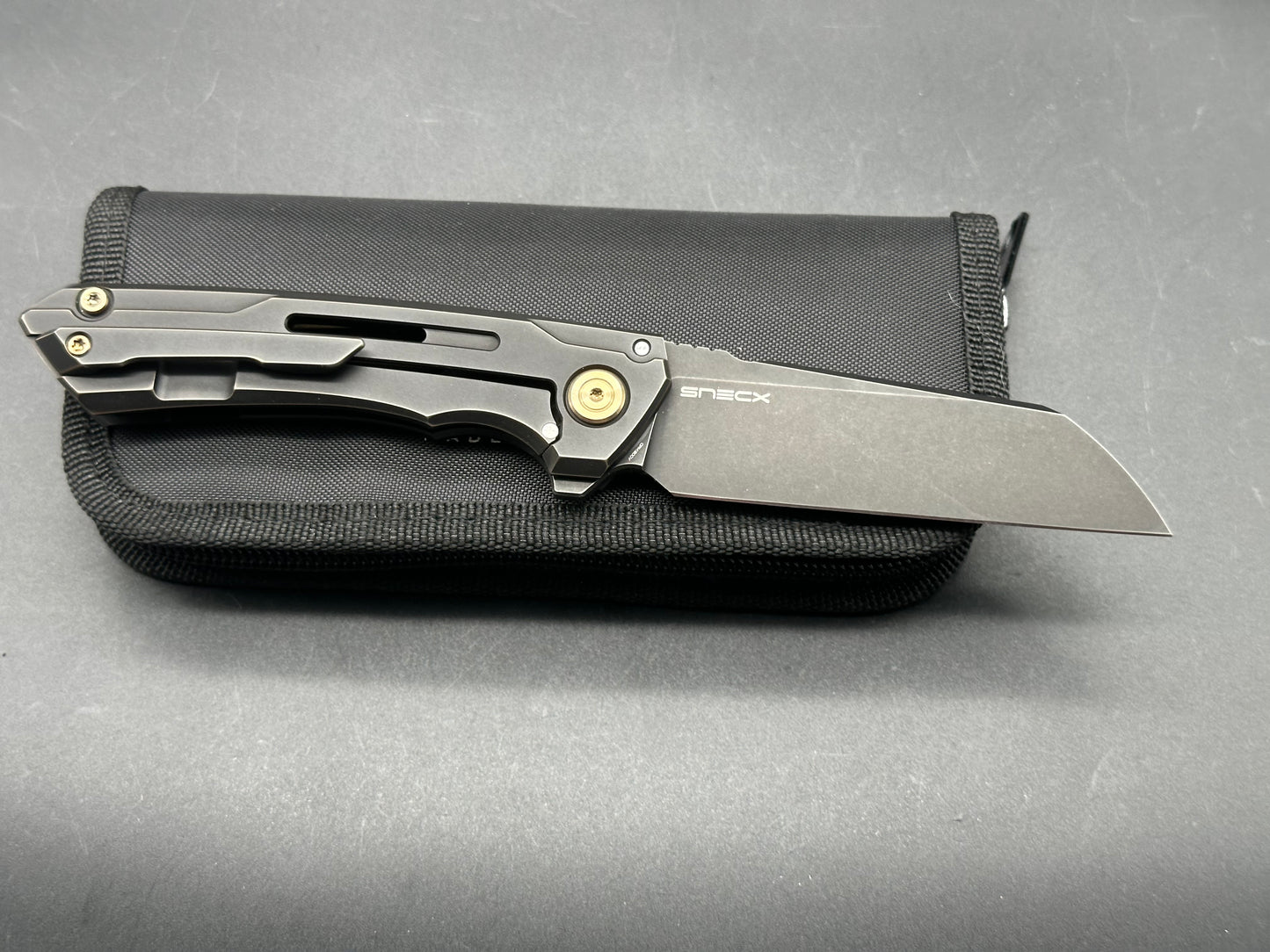 We Knives + SNECX - Mini Buster/Antique Bronze/Black Ti Handle